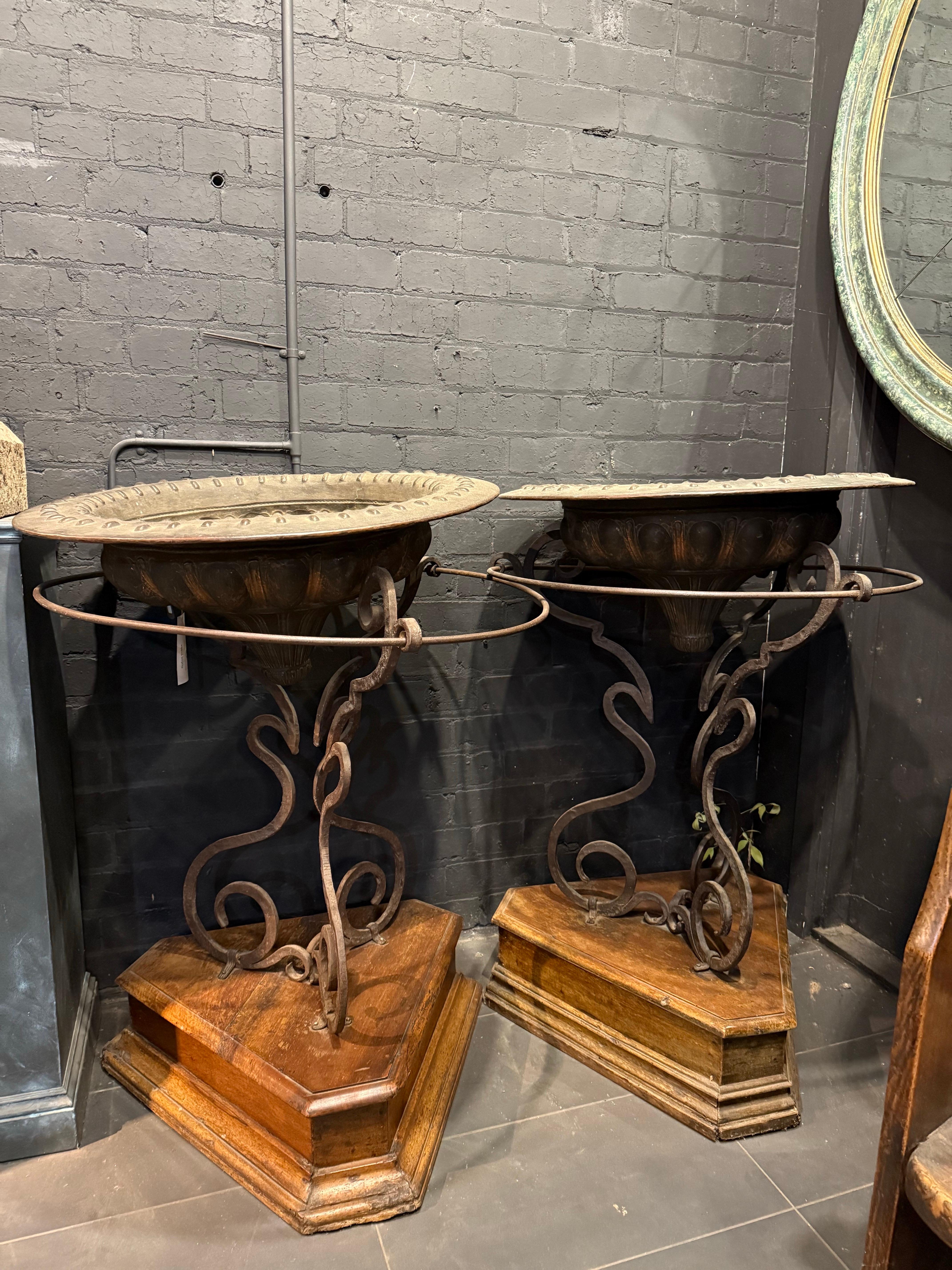 Ein Paar italienischer handgeschmiedeter Kupferbracieri auf eisernen Dreibeinständern und Holzsockeln, 18.

Jeweils in Form eines flachen Kraters mit breiter Öffnung und Cabochon-Motiv auf der Lippe, der geschwungene, mit Girlanden verzierte Körper