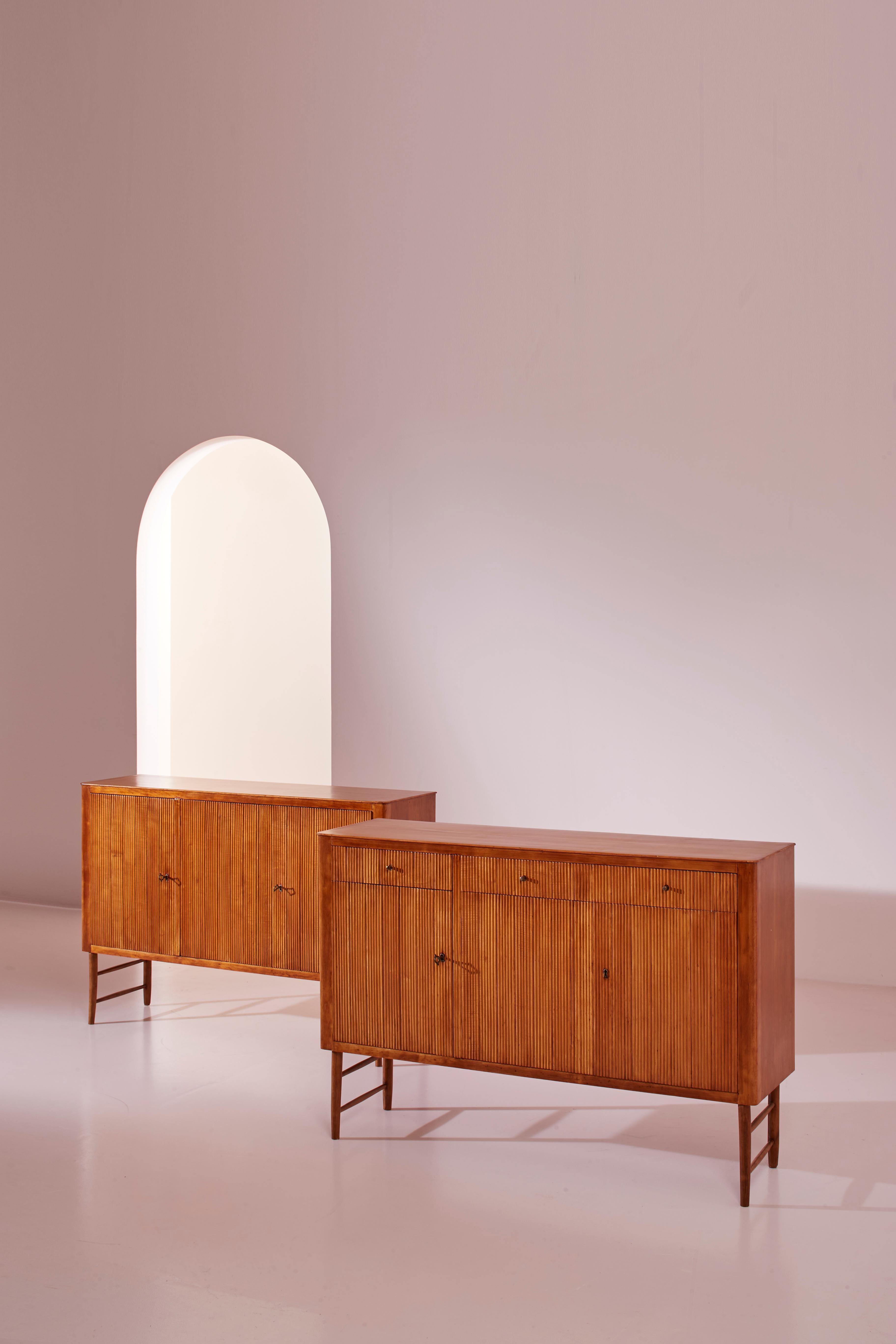 A pair of elegant maple wood credenzas with a grissinato finish, manufactured in the 1950s in the distinctive style of Paolo Buffa. 

Characterized by clean lines and refined design, these credenzas feature a smooth touch surface that enhances the