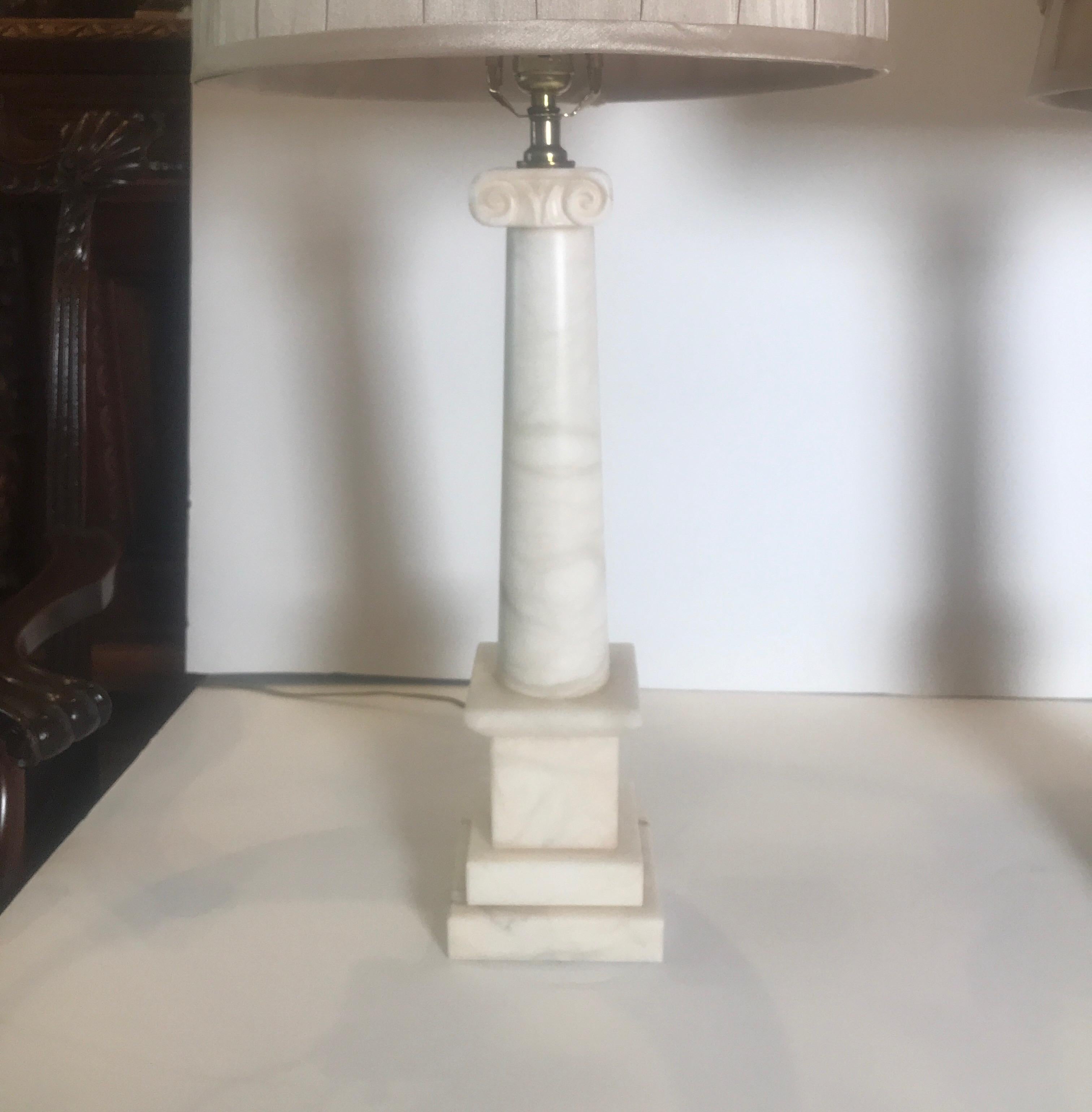 A pair of polished marble column lamps, Italy, circa 1950 the neoclassical form with tapering center column on stacked plinth base. The shades are for photographic purposes only and not included with the lamps. Measures: 23 inches tall to the top of