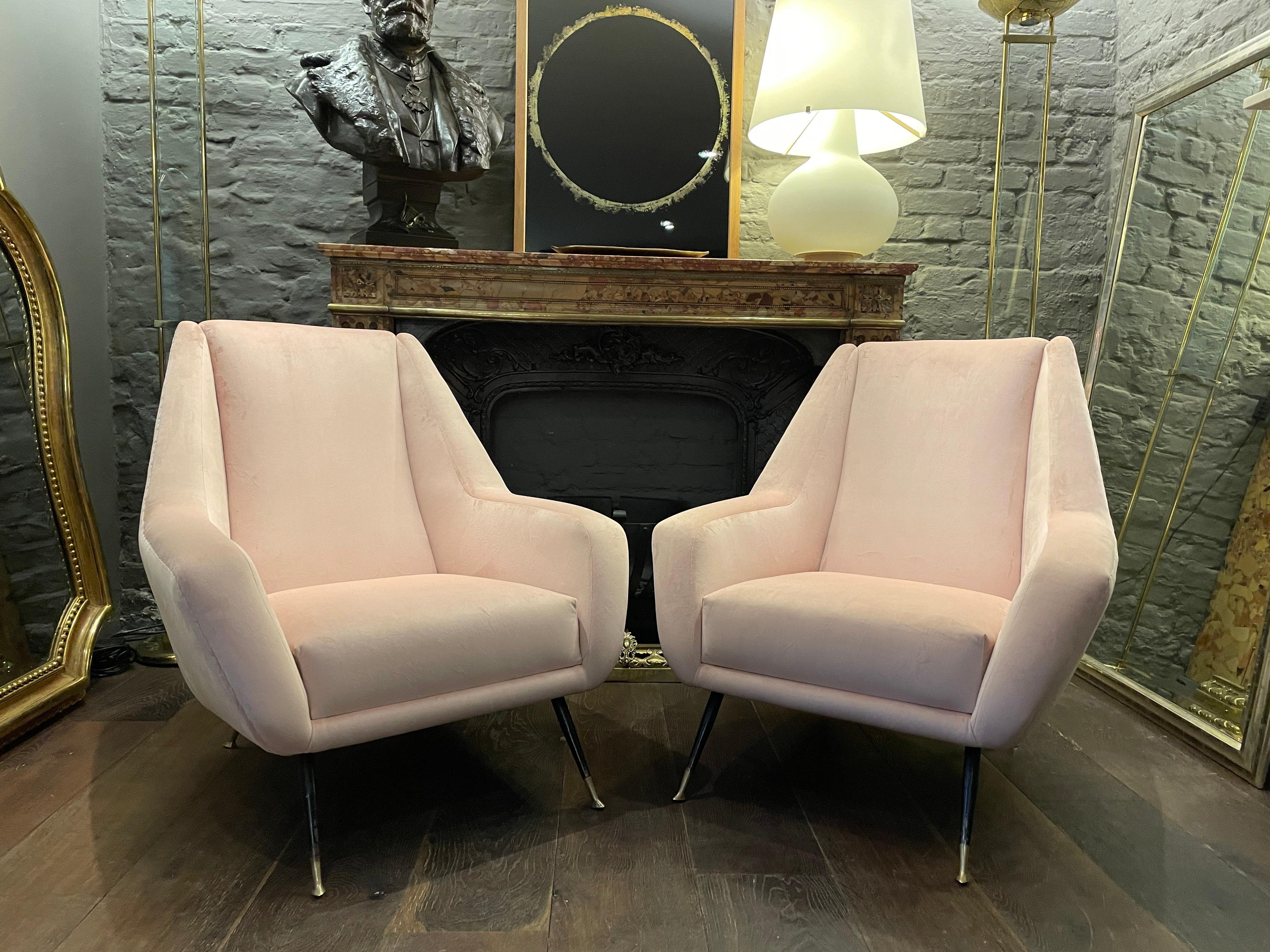 A Pair of Italian mid-century arm or lounge chairs. Newly re upholstered in blush pink velvet. The black steel legs with brass sabot feet. Large and comfortable.

Circa 1950.