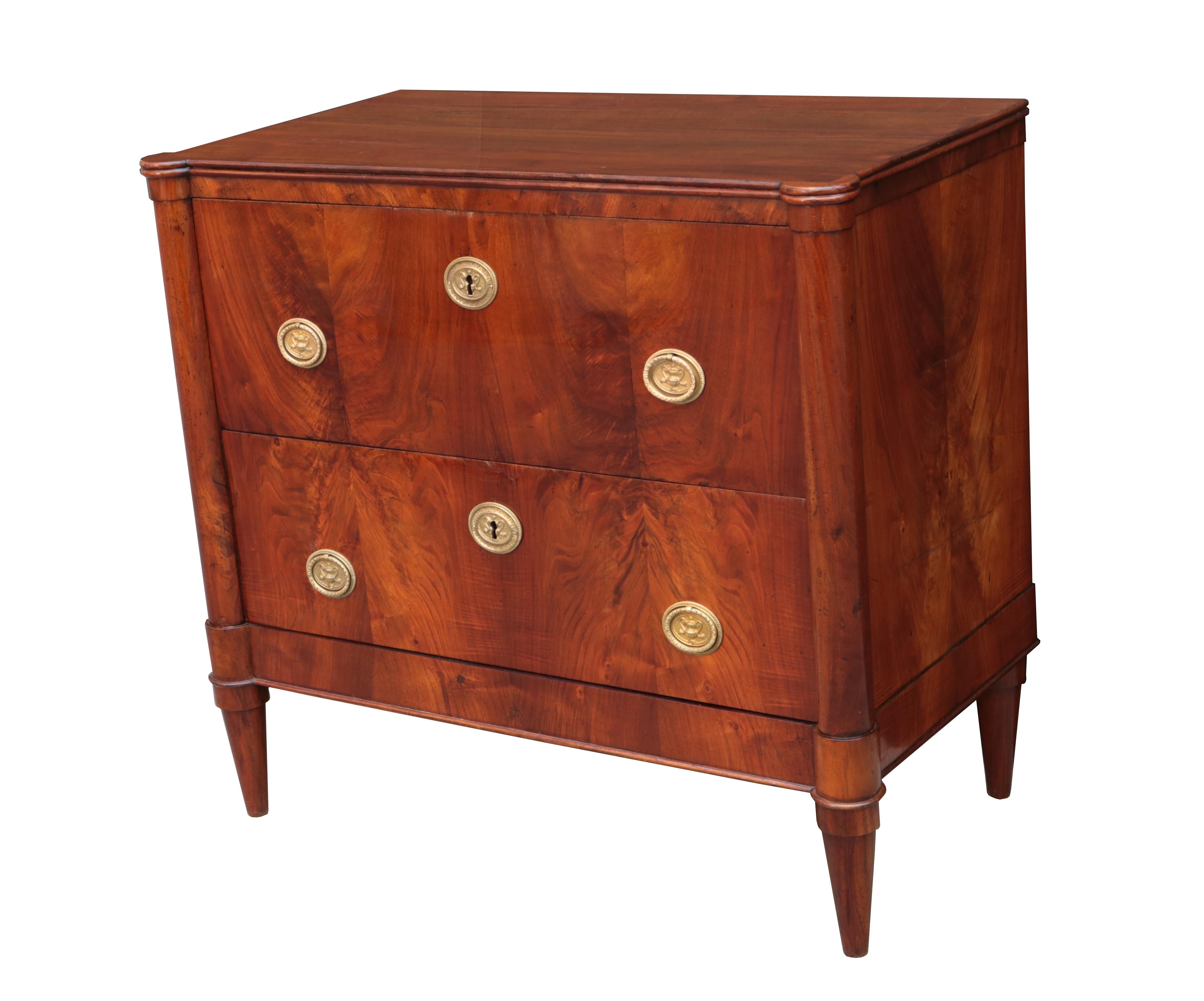 A pair of Italian Neoclassical style bedside chests.
Walnut with patinated brass pulls and escutcheons.
 