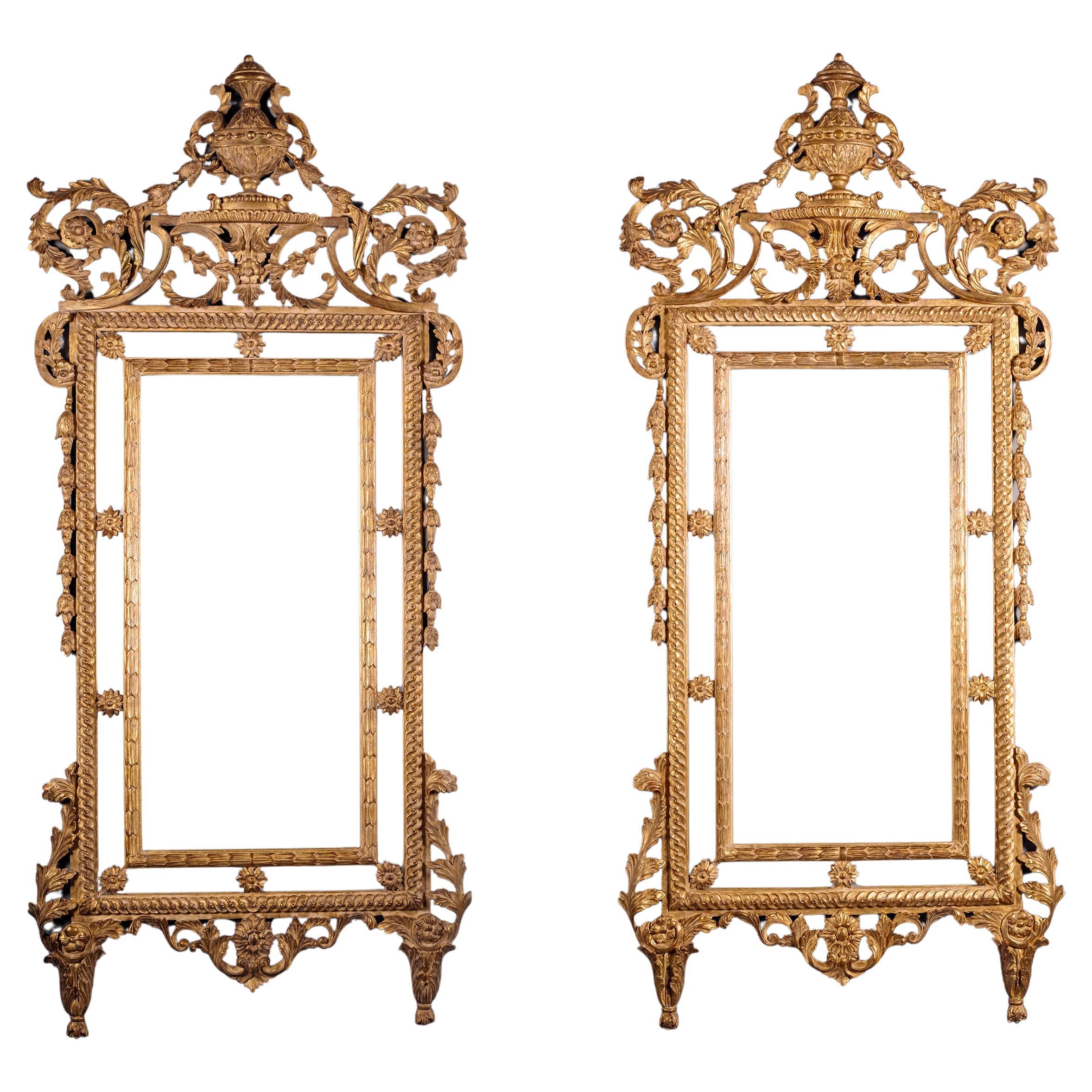 Coppia di specchi da molo neoclassici italiani in legno dorato. 
 
Ciascuna specchiera ha una lastra rettangolare con bordo interno intagliato a pula e bordi esterni specchiati divisi da rosette, la cornice entrelac sormontata da una cresta