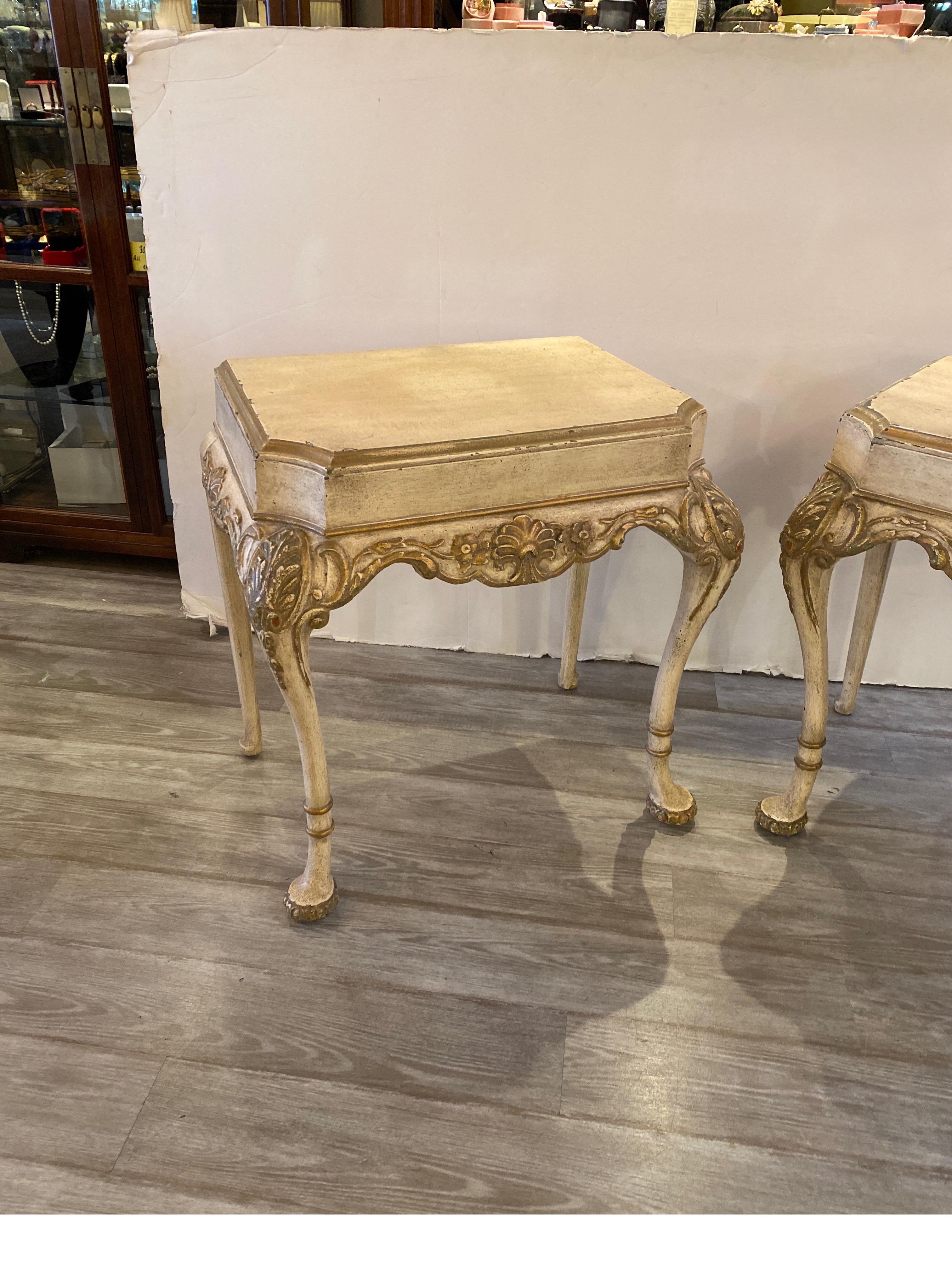 A pair of carved hardwood consoles made in Italy, circa 1900. The hardwood, probably walnut with a painted cream finish with gold accents. The painted finish with wear and some paint loss giving these pieces an old word feel