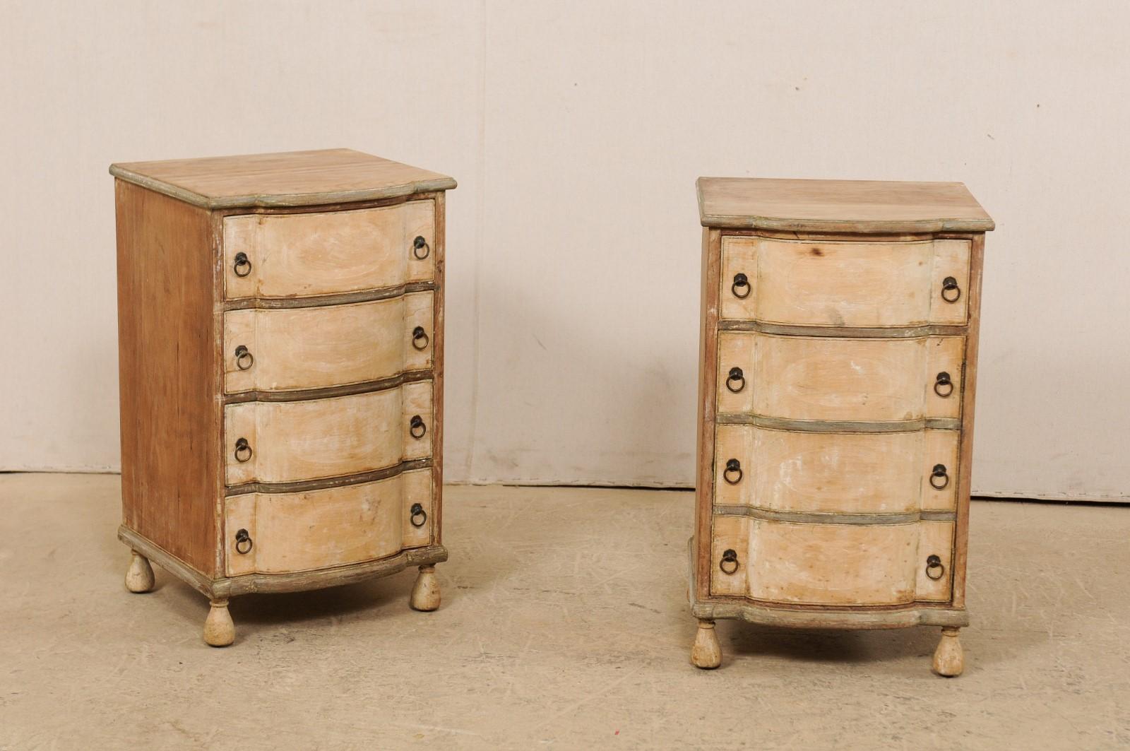 An Italian pair of small sized wooden chests from the 1920s-1930s. This antique pair of comodini from Italy each features a bow-front top over case with matching body, which houses a four-drawer front; however, only one of the commodes has four