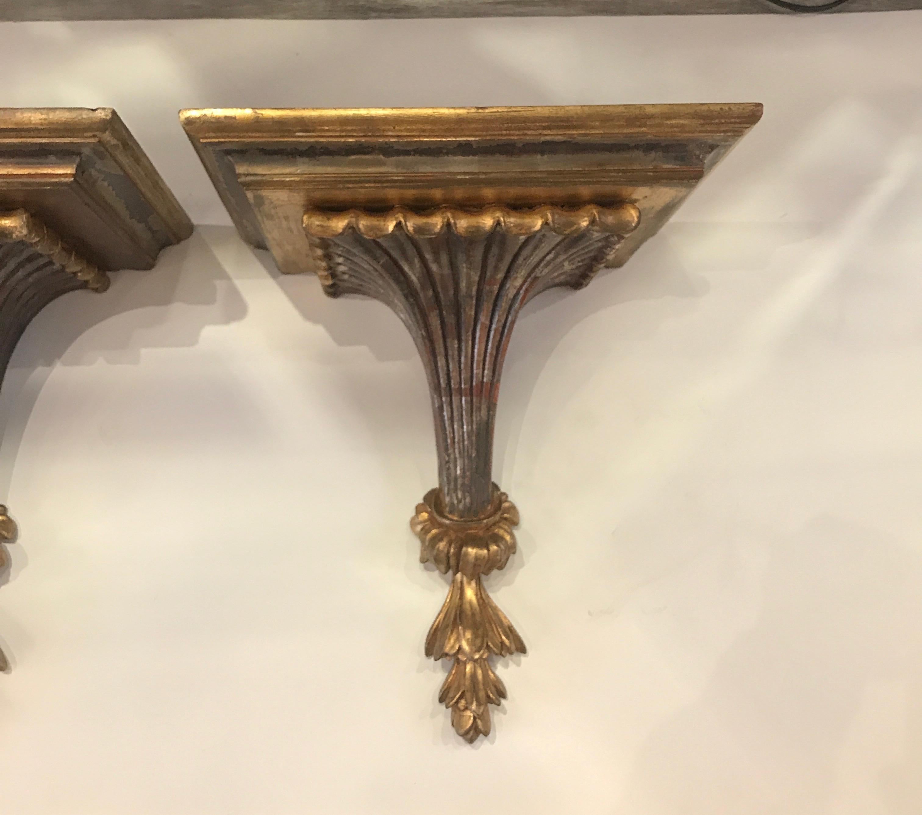 A pair of decorator carved Italian giltwood wall shelves. The generous sized top supported by fluted base. The top measures 12.5 wide, 9 deep with a height of 15.