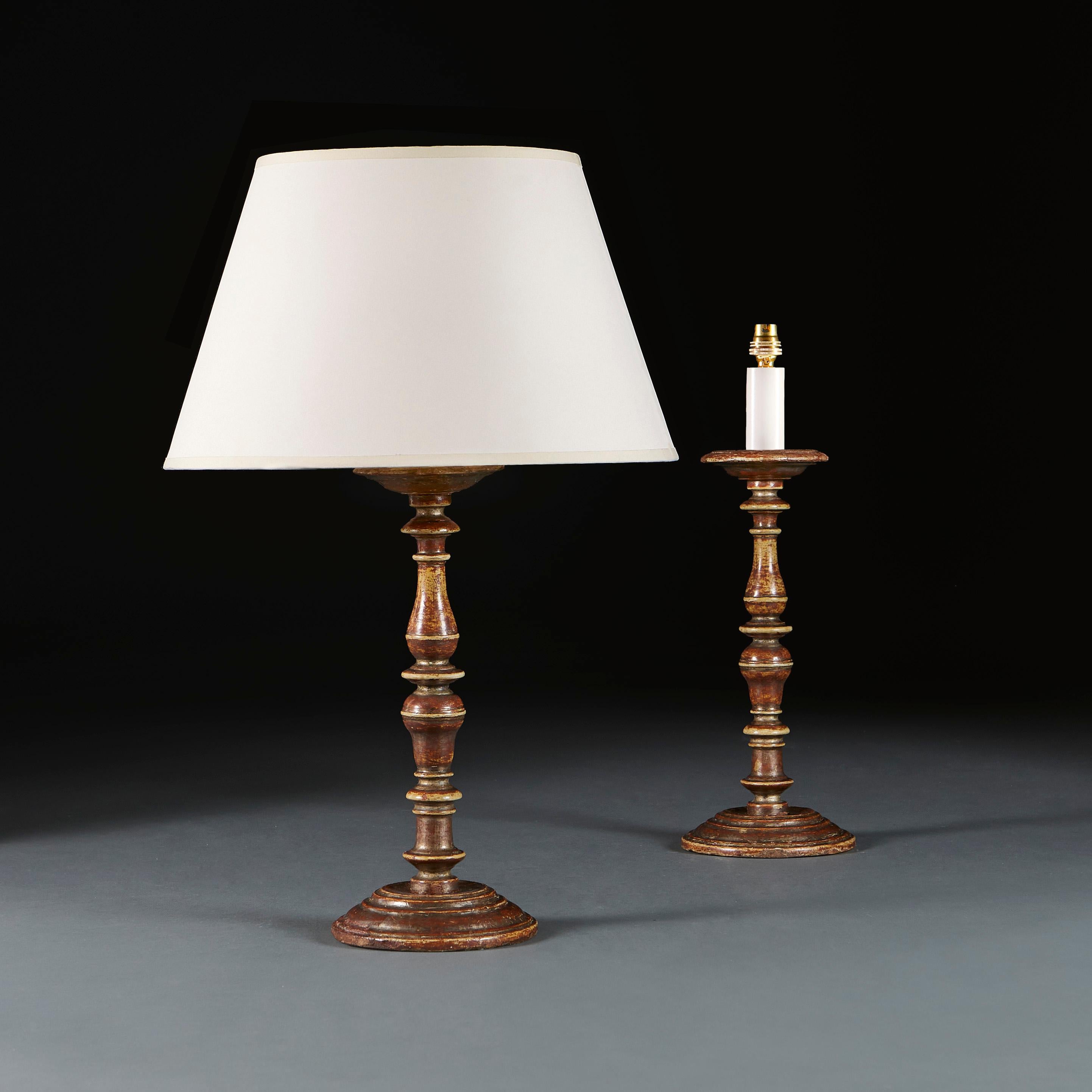 Italy, circa 1800

A fine pair of early nineteenth century turned candlesticks, with silver gilt surface, now worn through to reveal the red bouille beneath, now electrified as lamps.

Height 38.00cm
Height with shade 63.00cm
Diameter of base