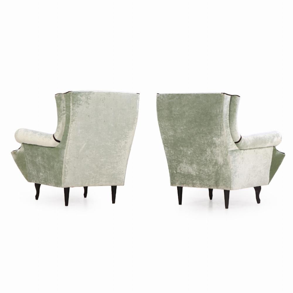 Récemment recouverte d'un nouveau tissu avec des passepoils contrastés foncés, cette magnifique paire de chaises de salon allie des éléments modernes et funky au confort d'un fauteuil à oreilles plus traditionnel.