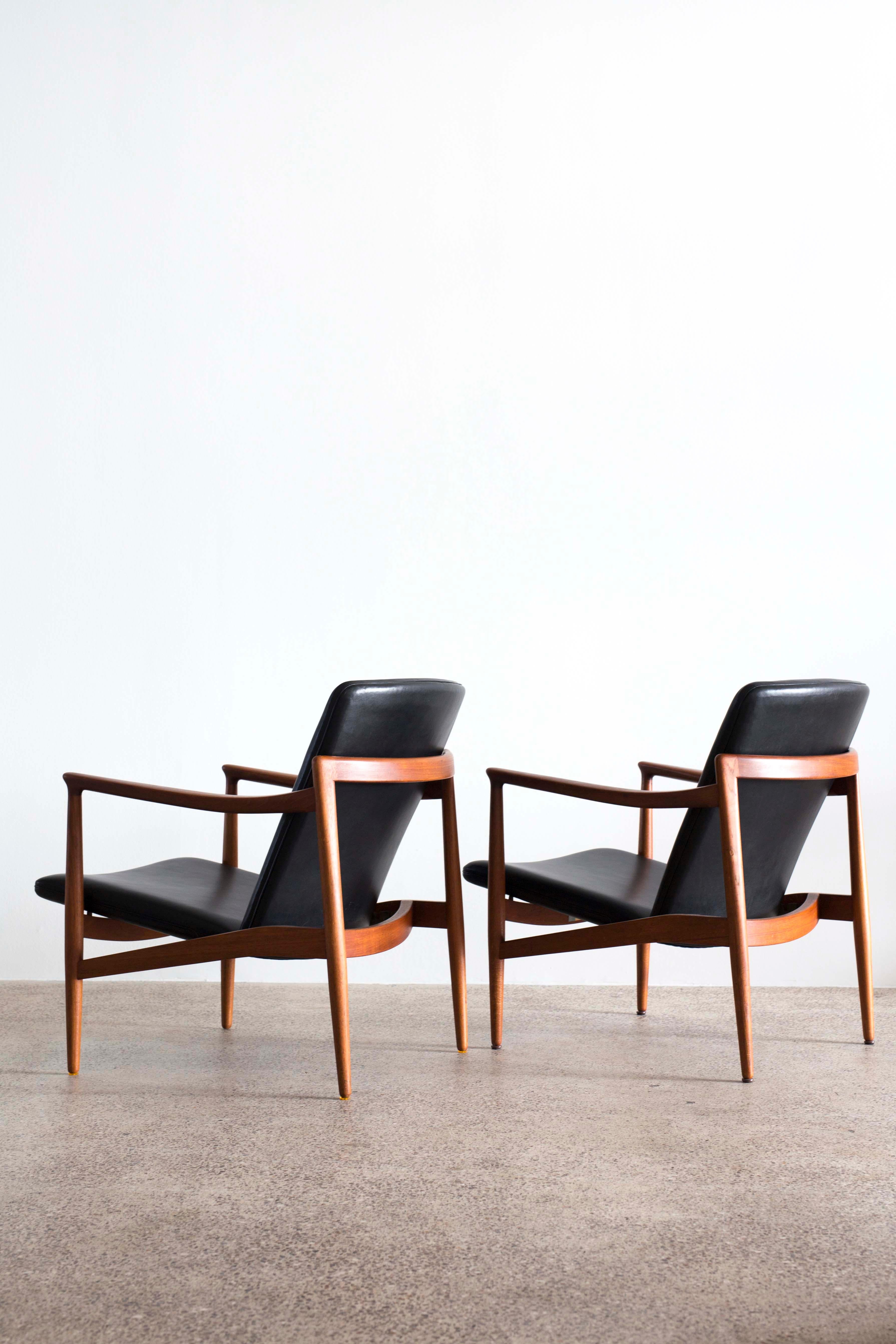 A pair of teak easy chairs designed and executed by Jacob Kjaer, Denmark.
Designed 1954 and made in 1962.
Black dyed natural leather upholstery, brass fittings and adjustable back.