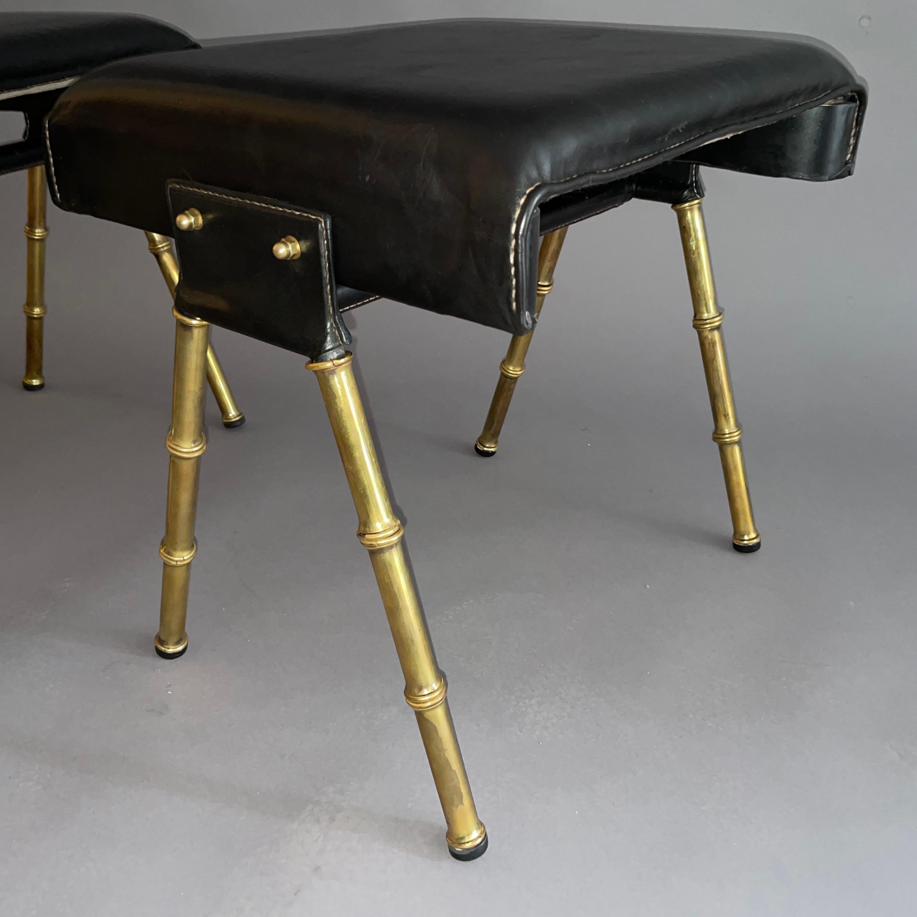 French A pair of Jacques Adnet black leather and brass stools For Sale