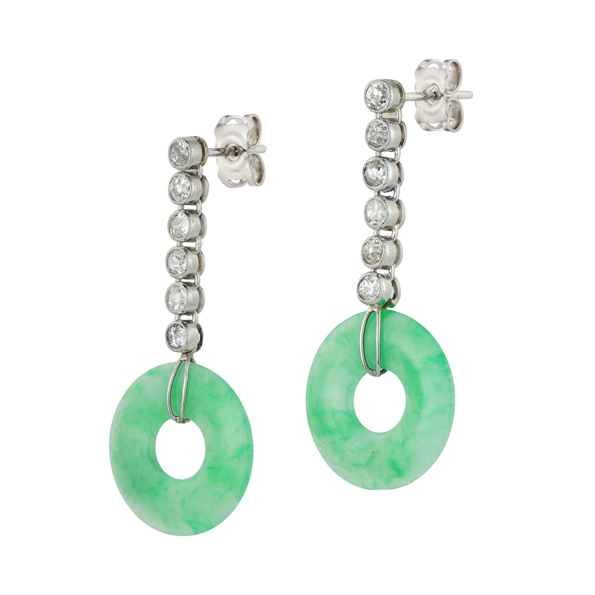 A pair of jade and diamond drop earrings, each earring with a circular jade disc with diameter 1.6 cm, accompanied by GCS Report 80261-09 stating to be natural with no indications of impregnation, each suspended by an articulated line of six old