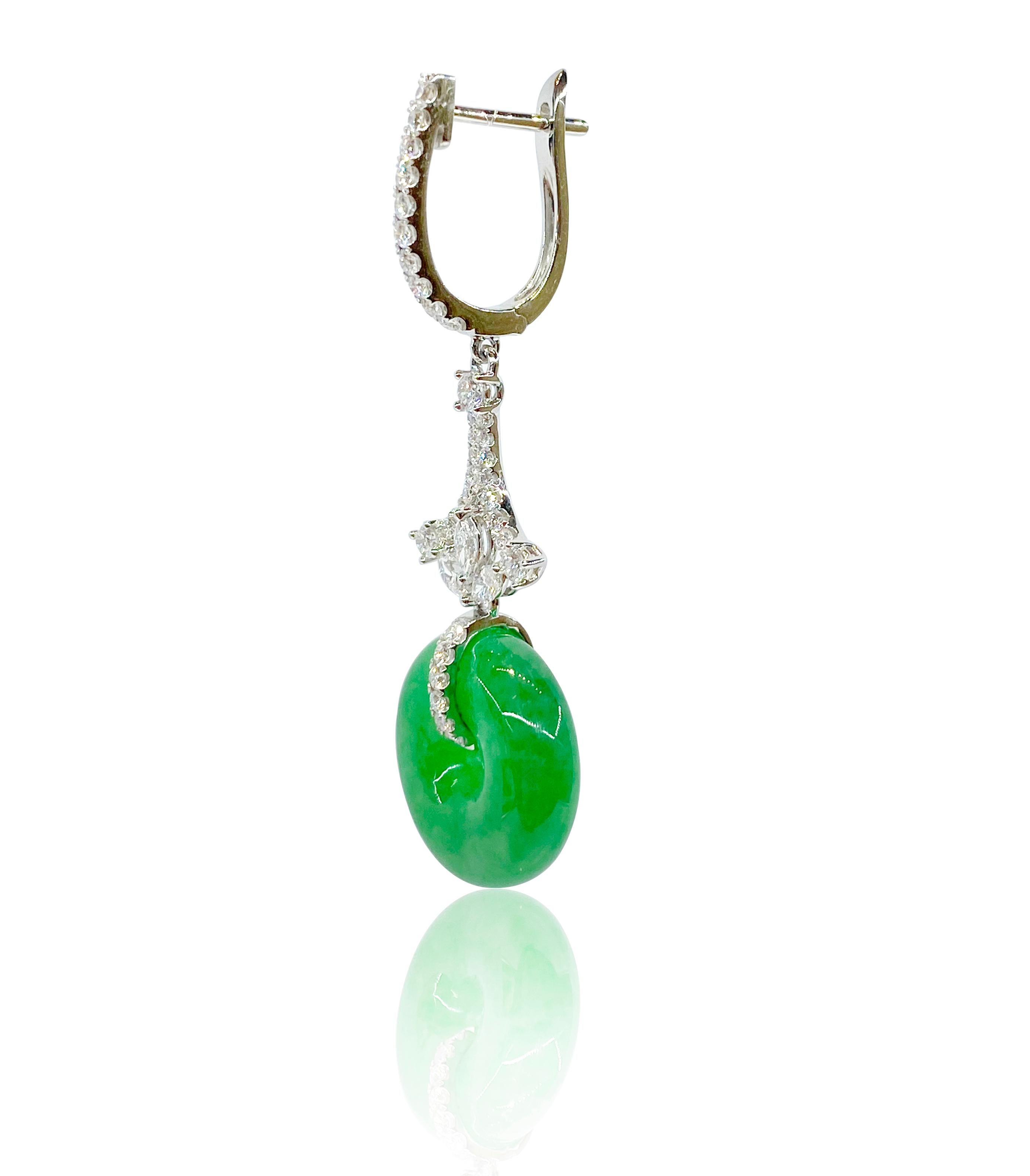 A pair of very fine jadeite and diamond earrings, each suspending a natural jadeite of brilliant emerald green colour and exceptional translucency, with brilliant and marquise diamonds weighing 1.03 carats, mounted in 18 Karat white gold. 