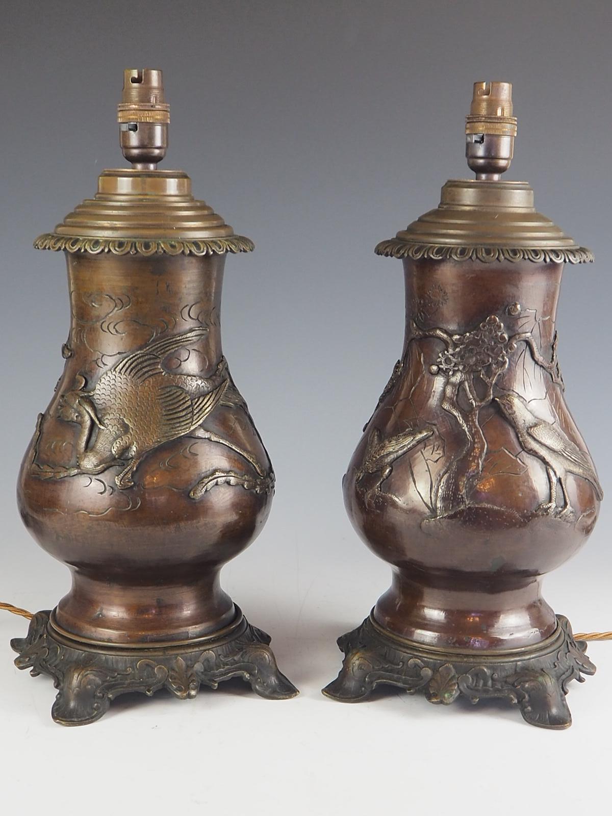 A beautiful pair of Japanese bronze oil lamps from c.1880 now converted to electricity.

Finely cast and detailed bronze with high relief impressive dragons, kites, birds, trees and fruit.

One vase is wrapped with a kite featuring a mythical