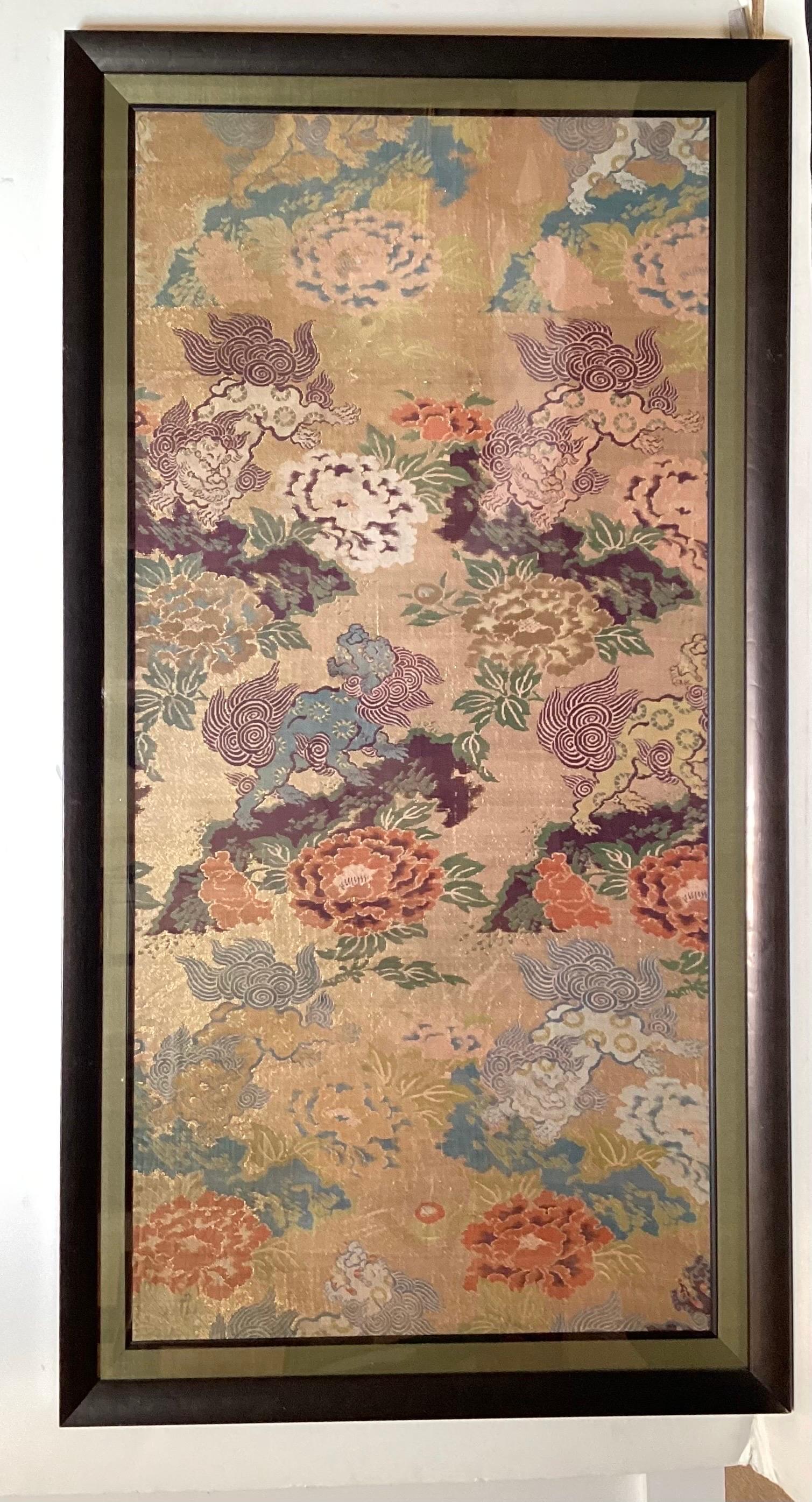A pair of framed Japanese silk brocade panels with frolicking SHi SHi on a gilt background. The panels on a raised suede matt, framed under plexiglass.