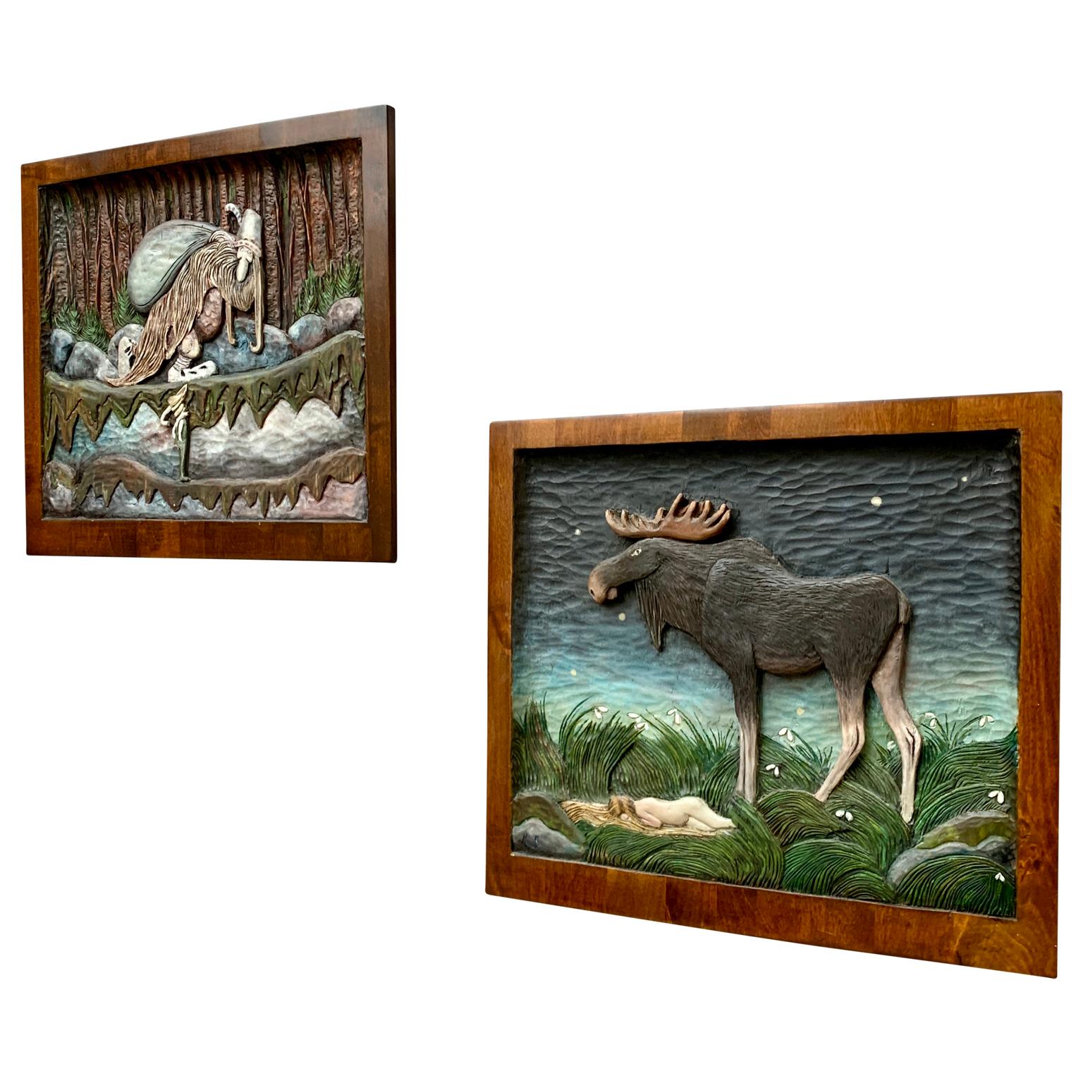 A pair of wooden carved and hand painted birch wood panels representing a moose and a troll with a child. These figures were taken from the famous Swedish painter and illustrator John Bauer (1882-1918) work 