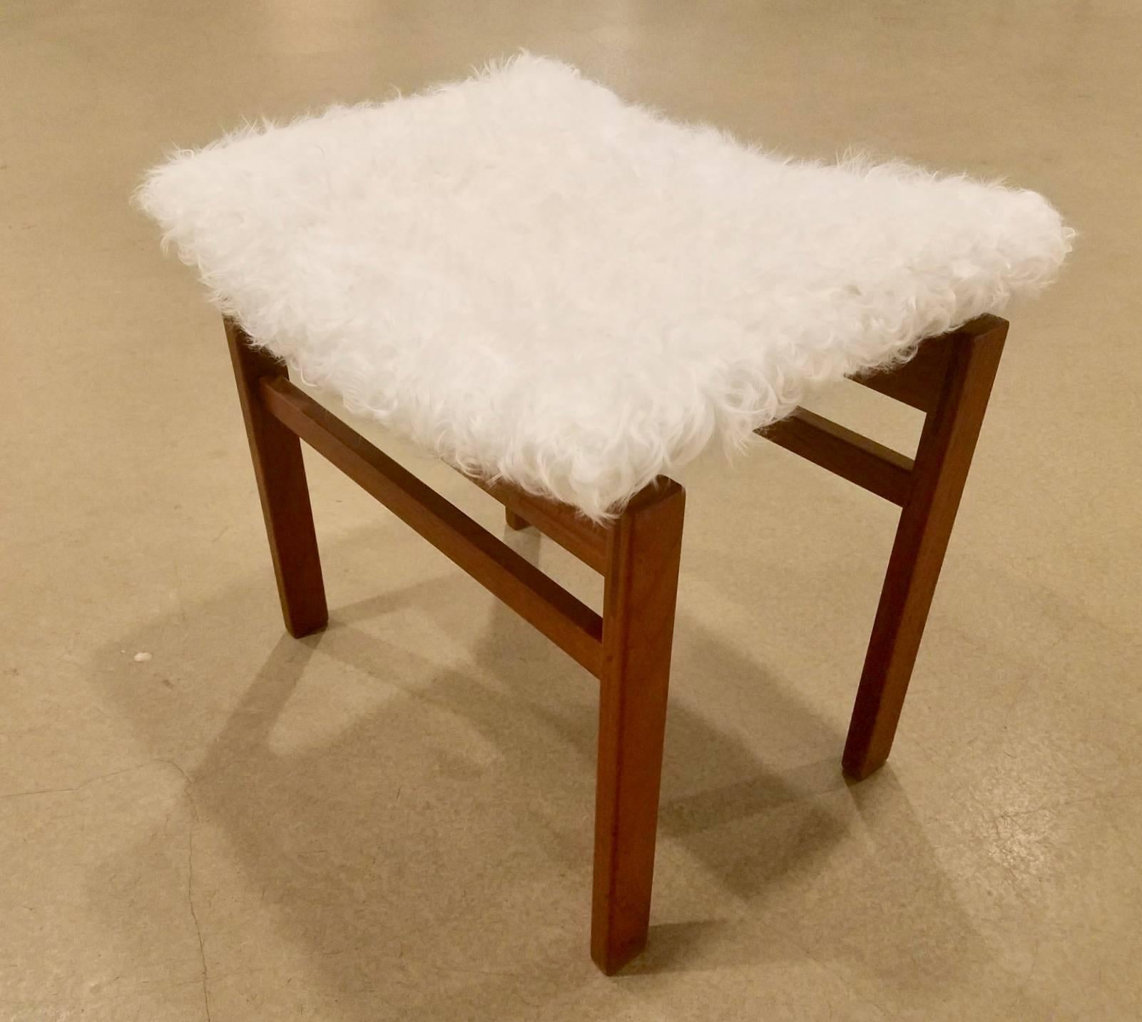 Un par de taburetes Finn Juhl para John Stuart, los asientos cóncavos descansan sobre
Madera de color rojizo recién tapizada en alpaca blanca con la etiqueta del fabricante en la parte inferior.