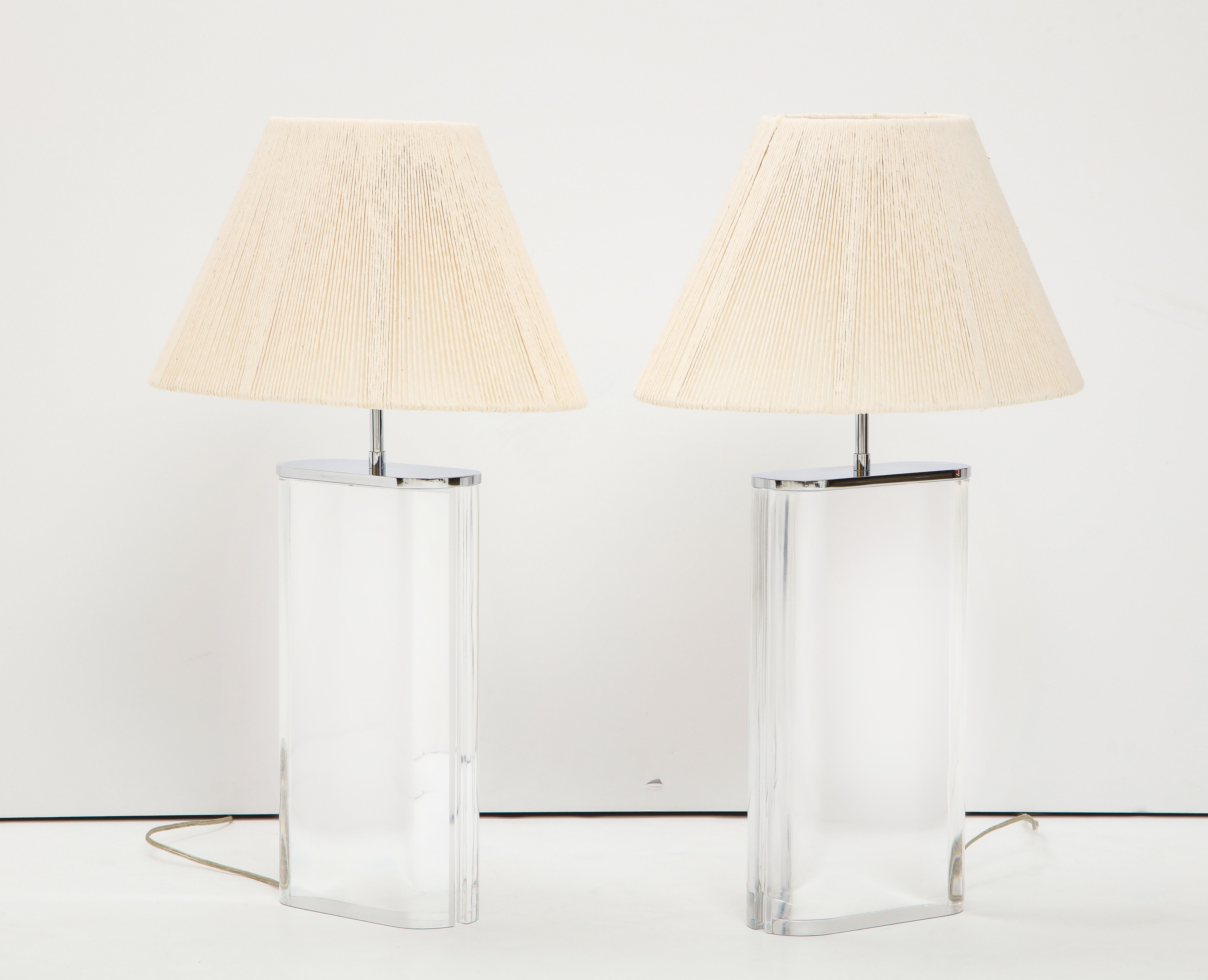 A large scale pair of Lucite and chrome mounted oblong form table lamps by Karl Springer. Purchased from Karl Springer circa 1982-1984, with custom made spring shades. Adjustable height.

Measures: Lucite base 16 3/8” H x 9” W x 3 ½” D
 
Overall