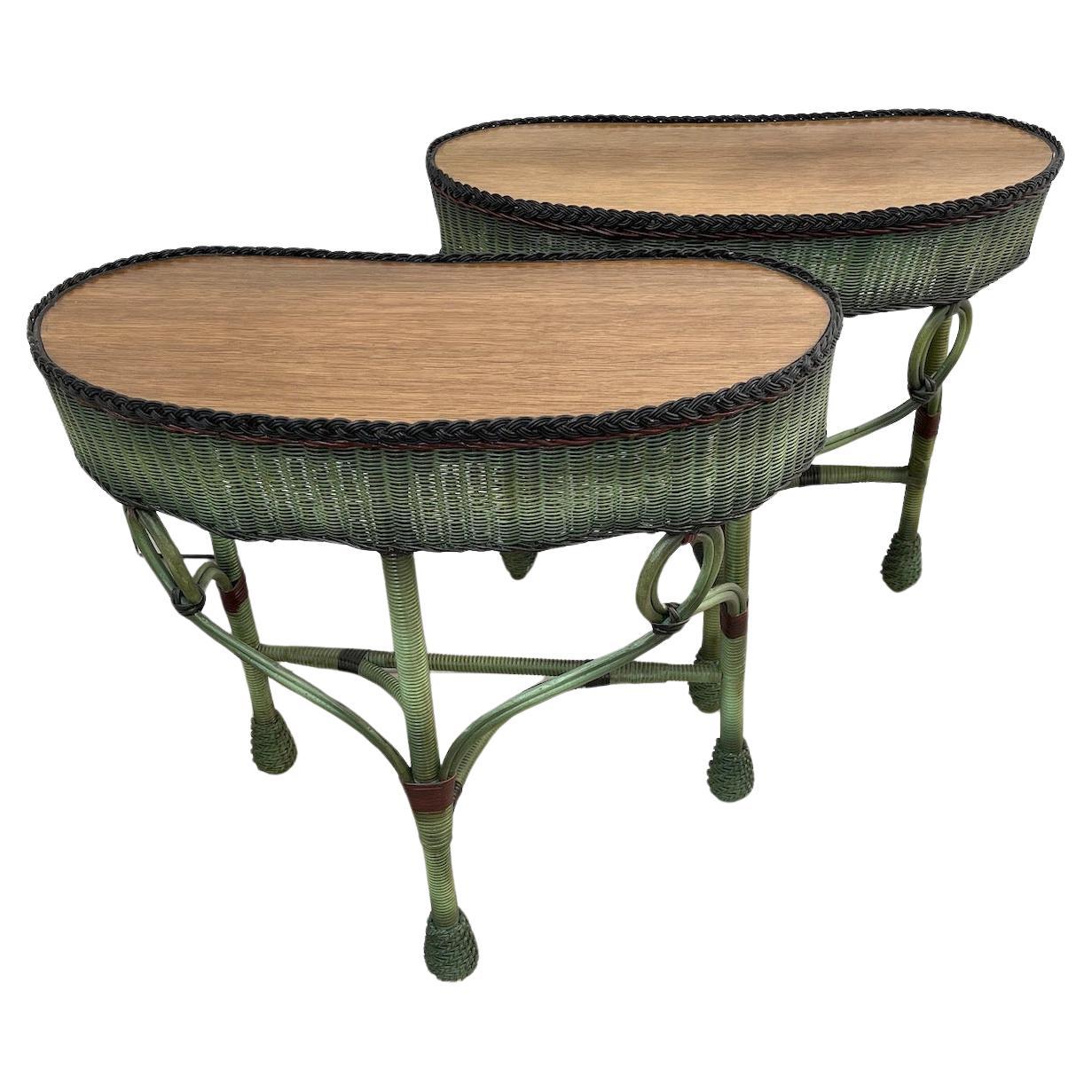  A unique matched pair of kidney shaped wicker three legged side tables labeled Heywood Wakefield Company, Gardner Ma. The tables  are done in a lovely shaded French green finish with black braid and red and black decorative accents, Each piece has