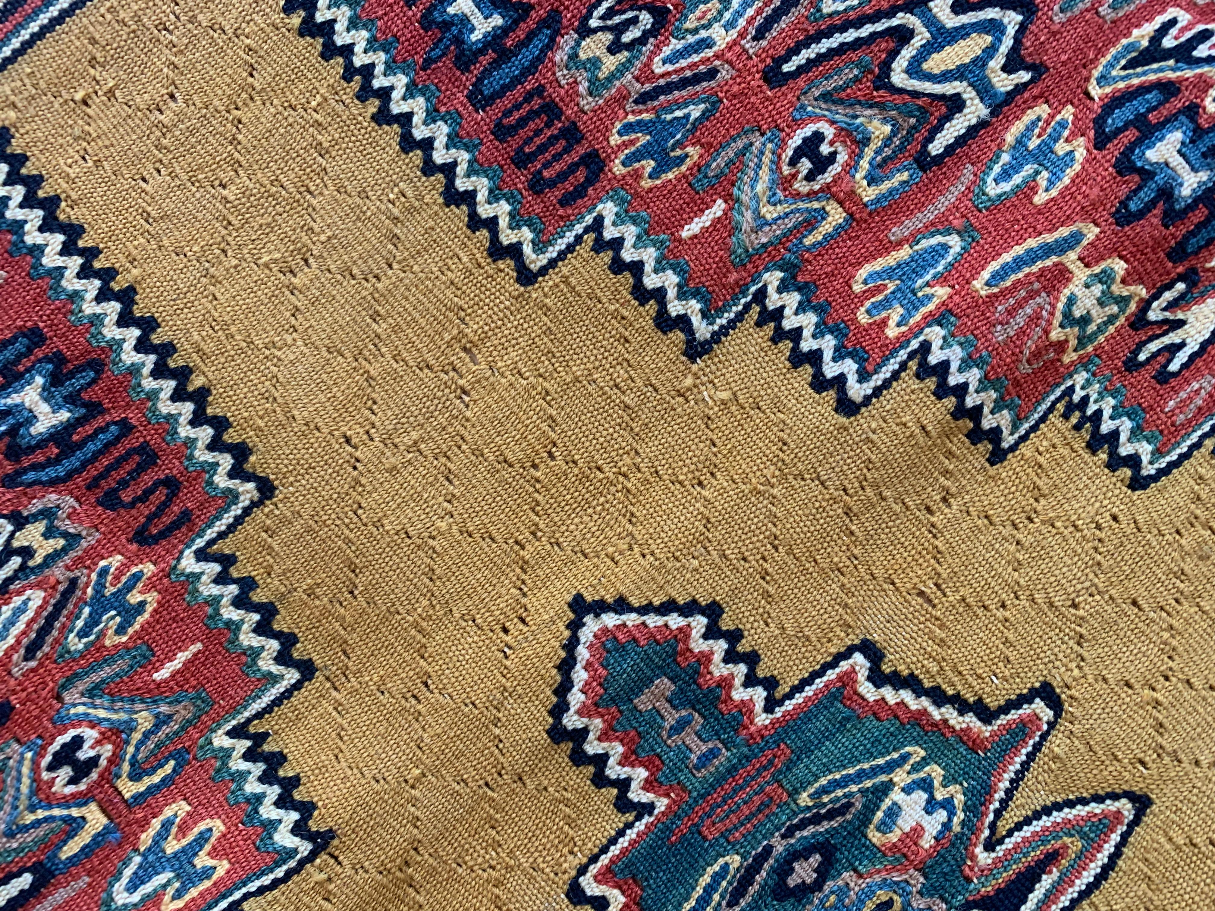 These bold wool rugs are a matching pair of handmade flatwoven kilims, woven by hand in the early 2000s, circa 2010. The design features geometric medallion woven in accents of ivory, green and red on a yellow background. This has then been framed