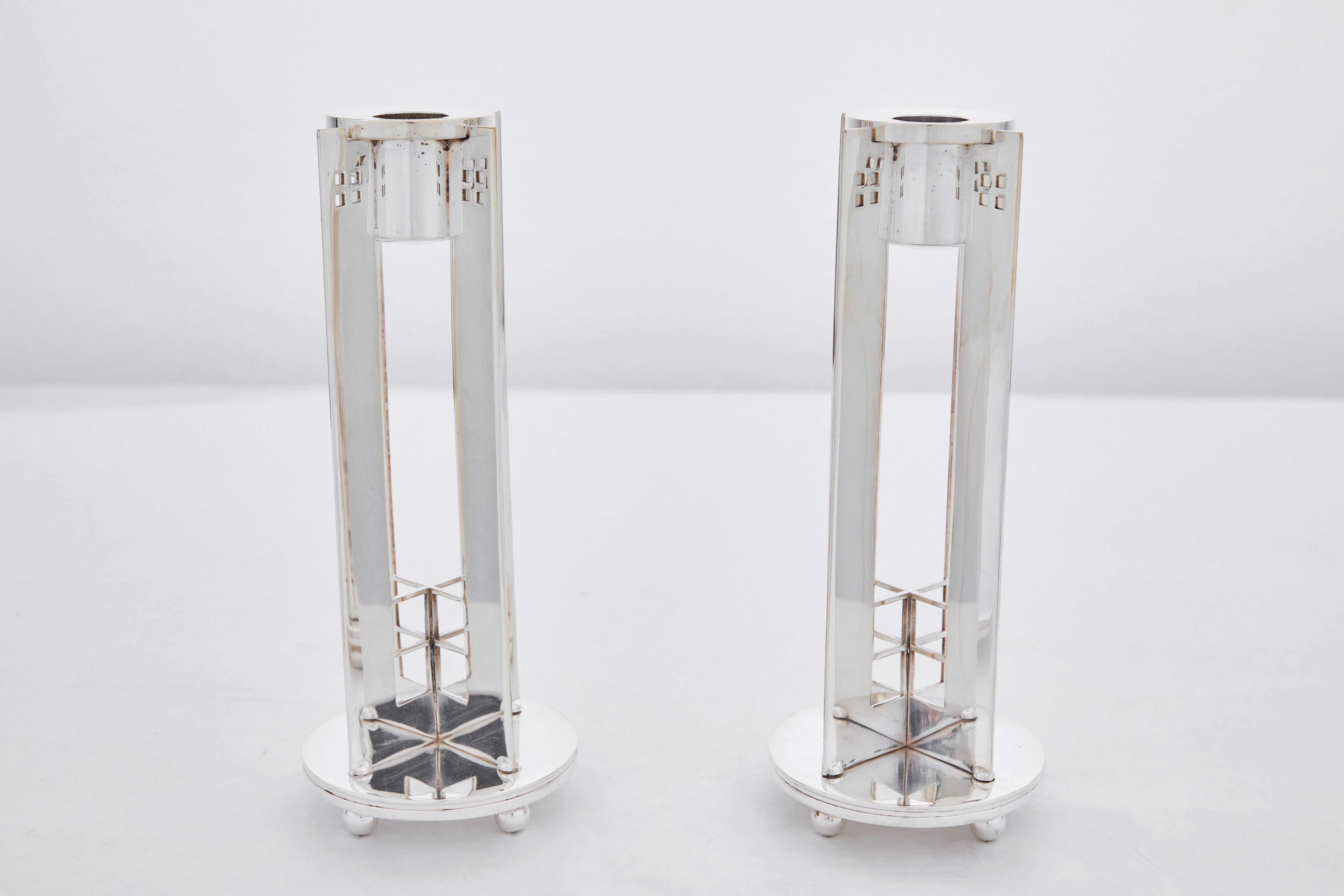 This is a pair of silver plated King Richard candle holders. These sculpturally modernist candle holders were designed by American Architect Richard Meier for Swid Powell. Founded in 1982, Swid Powell produced stylish and utilitarian home decor