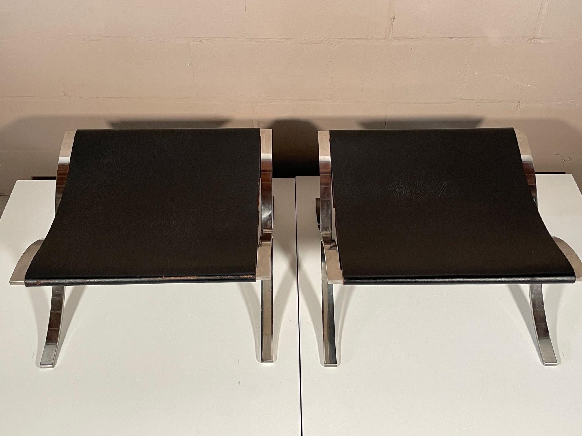A pair of vintage stools designed by Mies Van Der Rohe, manufactured by Knoll ca' 1960's. Solid chromed stainless steel X bases and thick, original belting leather. Very good overall condition. These were primarily used as ottomans, foot stools or