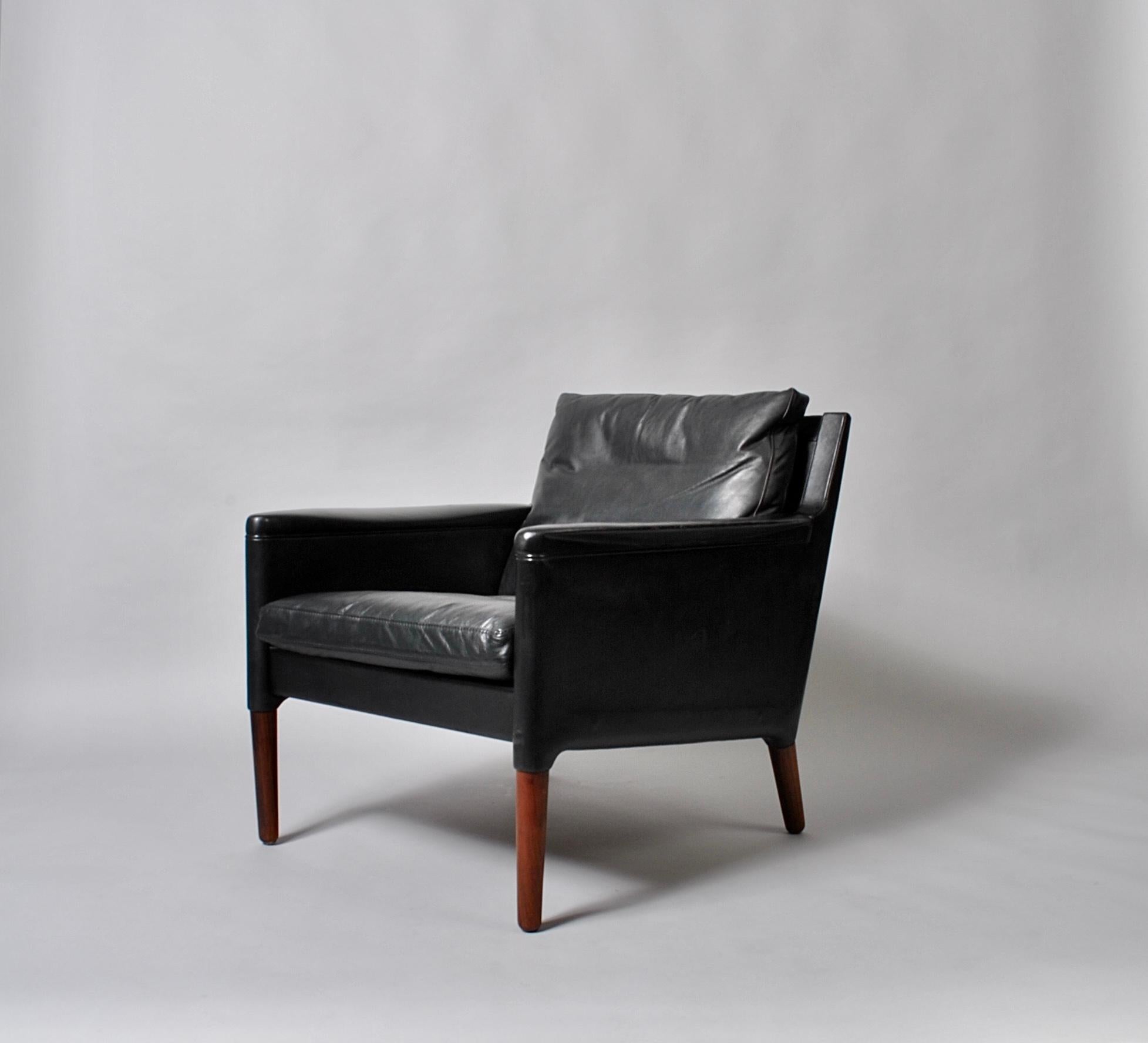 A rather rare matching pair of Kurt Ostervig model 55 lounge, club chairs. Lovely soft feather filled black leather cushions. Produced by Centrum Møbler in Denmark, circa 1960. Superb midcentury design by Ostervig. Sweeping rounded arms and a slick
