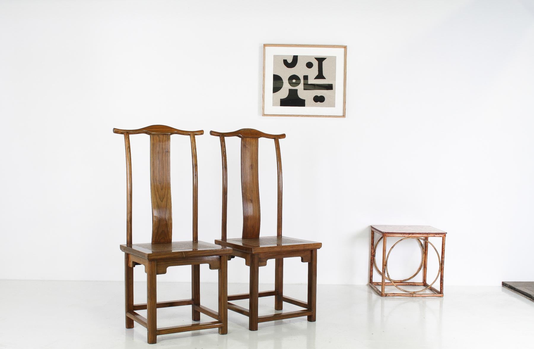 Paire de chaises à chapeau officielles du début du 20e siècle en orme de Chine avec dossier à empiècement
Ces chaises élégamment fabriquées présentent un design gracieux et harmonieux qui s'inspire de l'esthétique classique du mobilier chinois