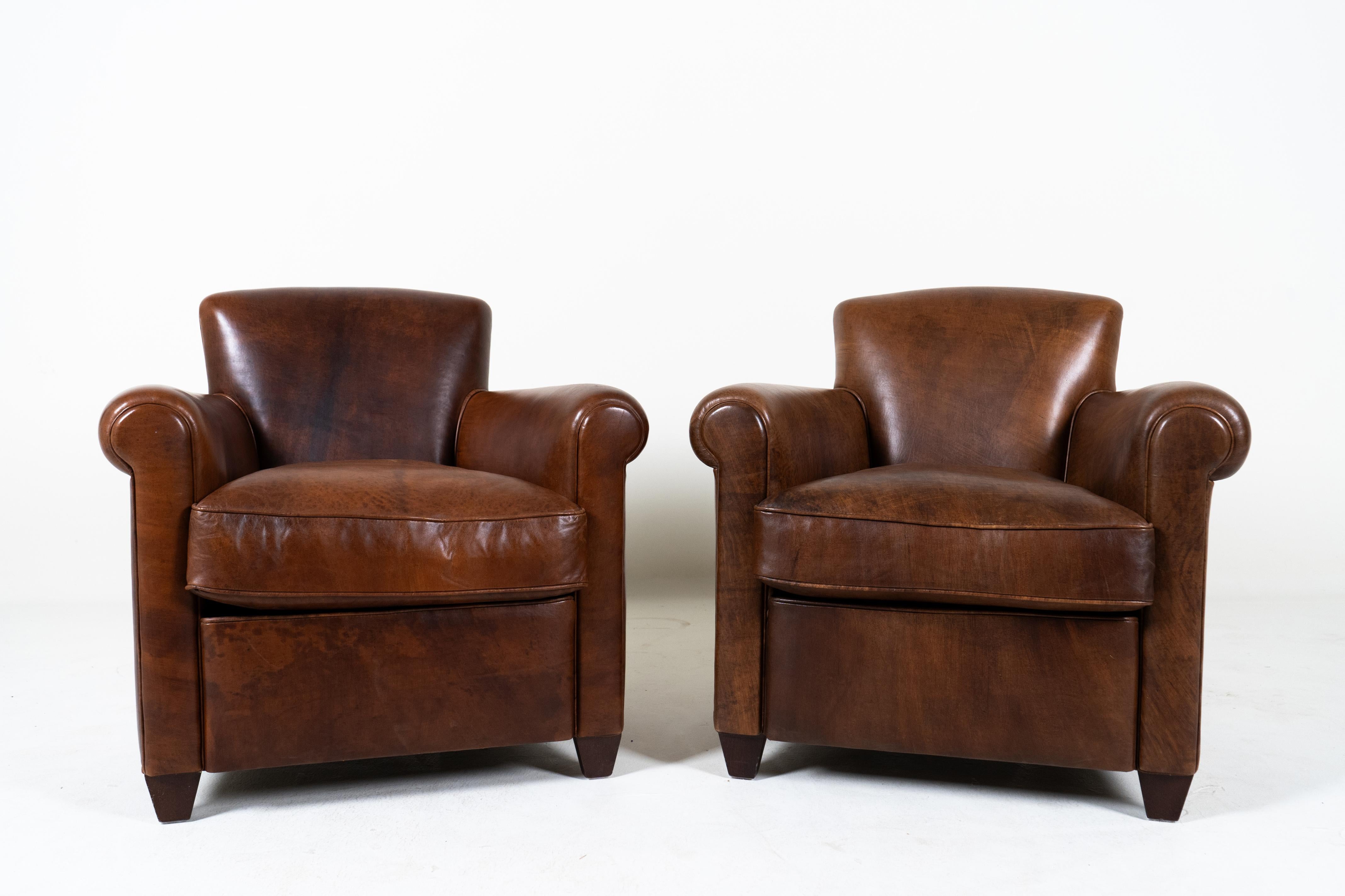 This pair of contemporary French Art Deco club chairs are a special find. With a design dating to the Art Deco period of the 1920s-1940s, these chairs define an era of Parisian elegance and comfort. The delicate nut-brown color has a beautiful