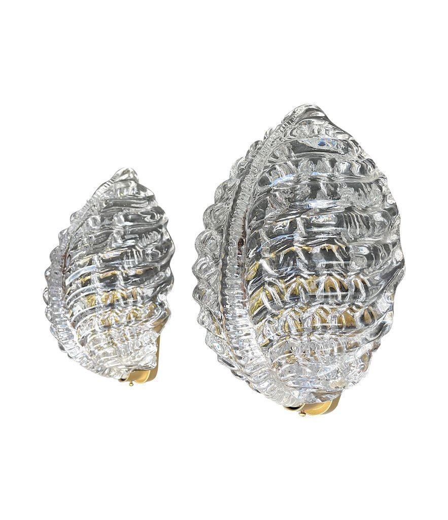 Pareja de grandes apliques Orrefors de cristal transparente y hojas, de Fritz Kurz, de la década de 1940, con herrajes de latón. Son apliques de gran calidad. Recableado con accesorios de latón nuevos y prueba PAT .
Hay 5 luces disponibles y el