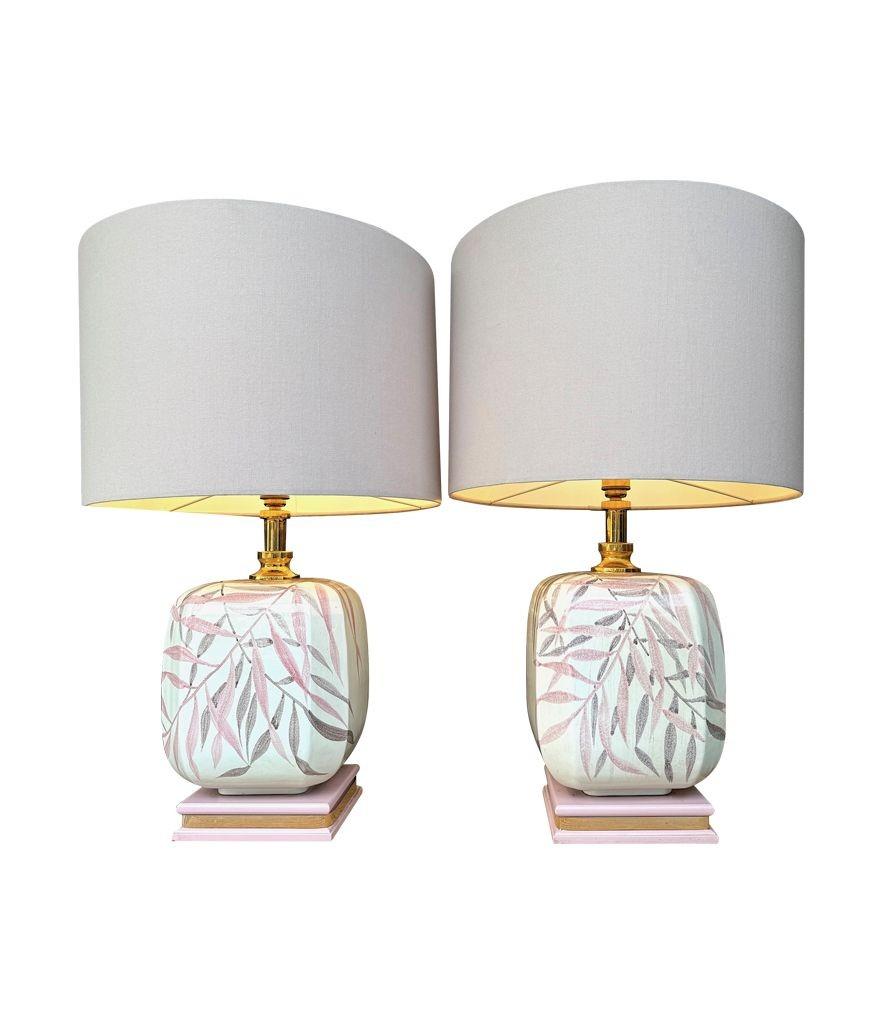 Coppia di grandi lampade in ceramica dipinte a mano negli anni '70 da Ugo Zaccanini per Maison Lancel con disegni di foglie di bambù rosa e grigie, accessori in ottone e montate su basi in legno rosa e ottone. Ricablata con nuovi accessori in
