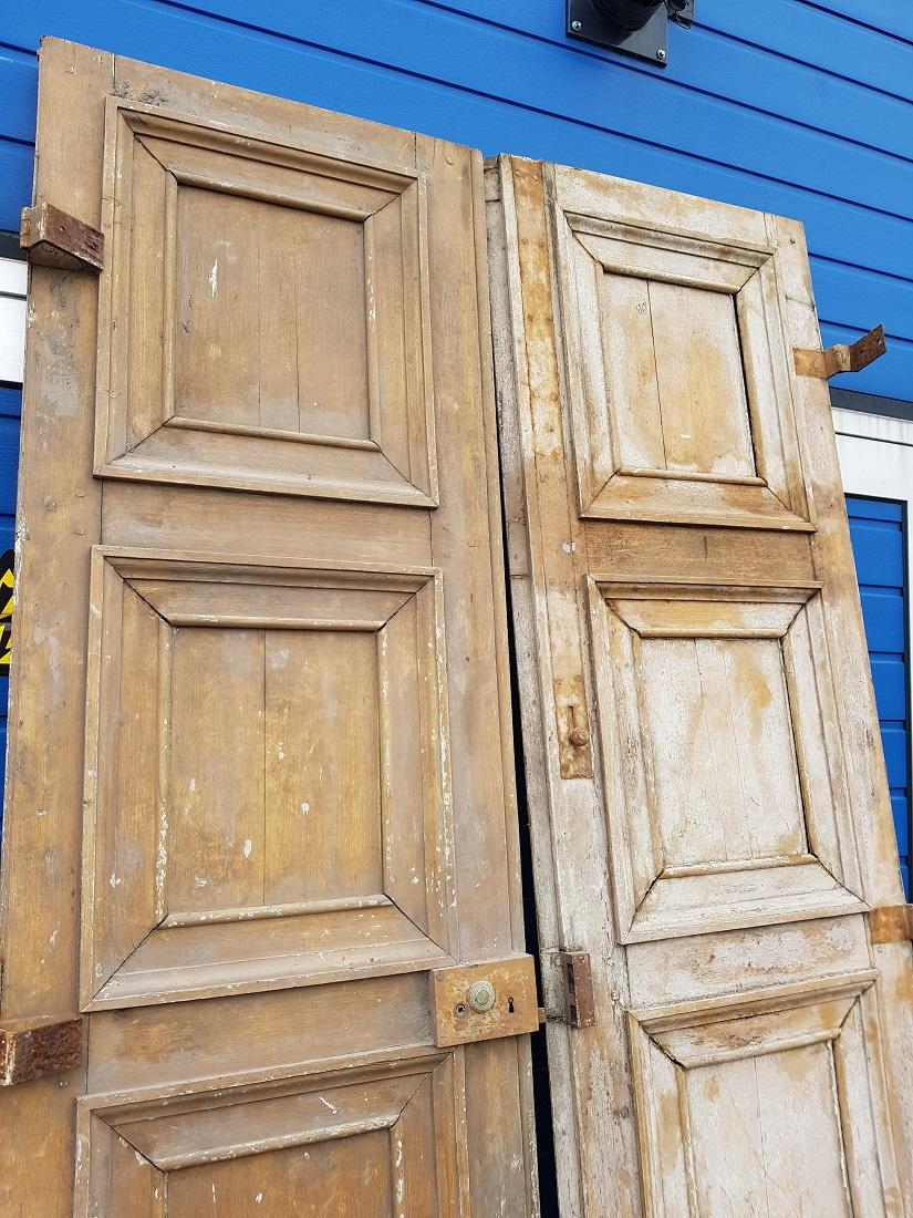 A pair of large antique French oak doors decorated with square panels on both sides including hinges and locks including the key, this is a barn find and are in a good but used and weathered condition. Originating from the 19th century.

The