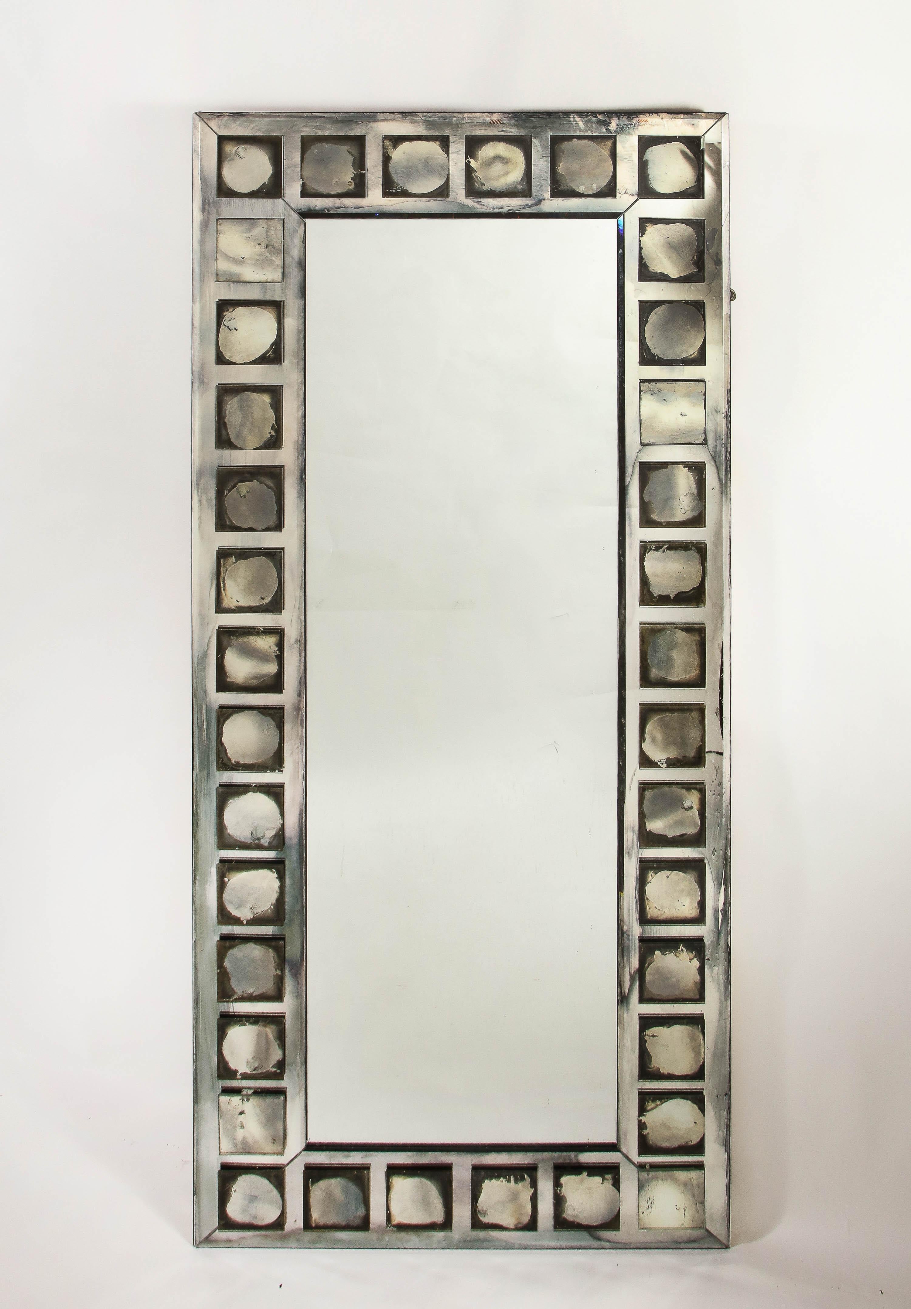 A pair of unique and large French geometric rectangular form mirrors of unusual design embellished with square shaped antiqued mirrored panels.