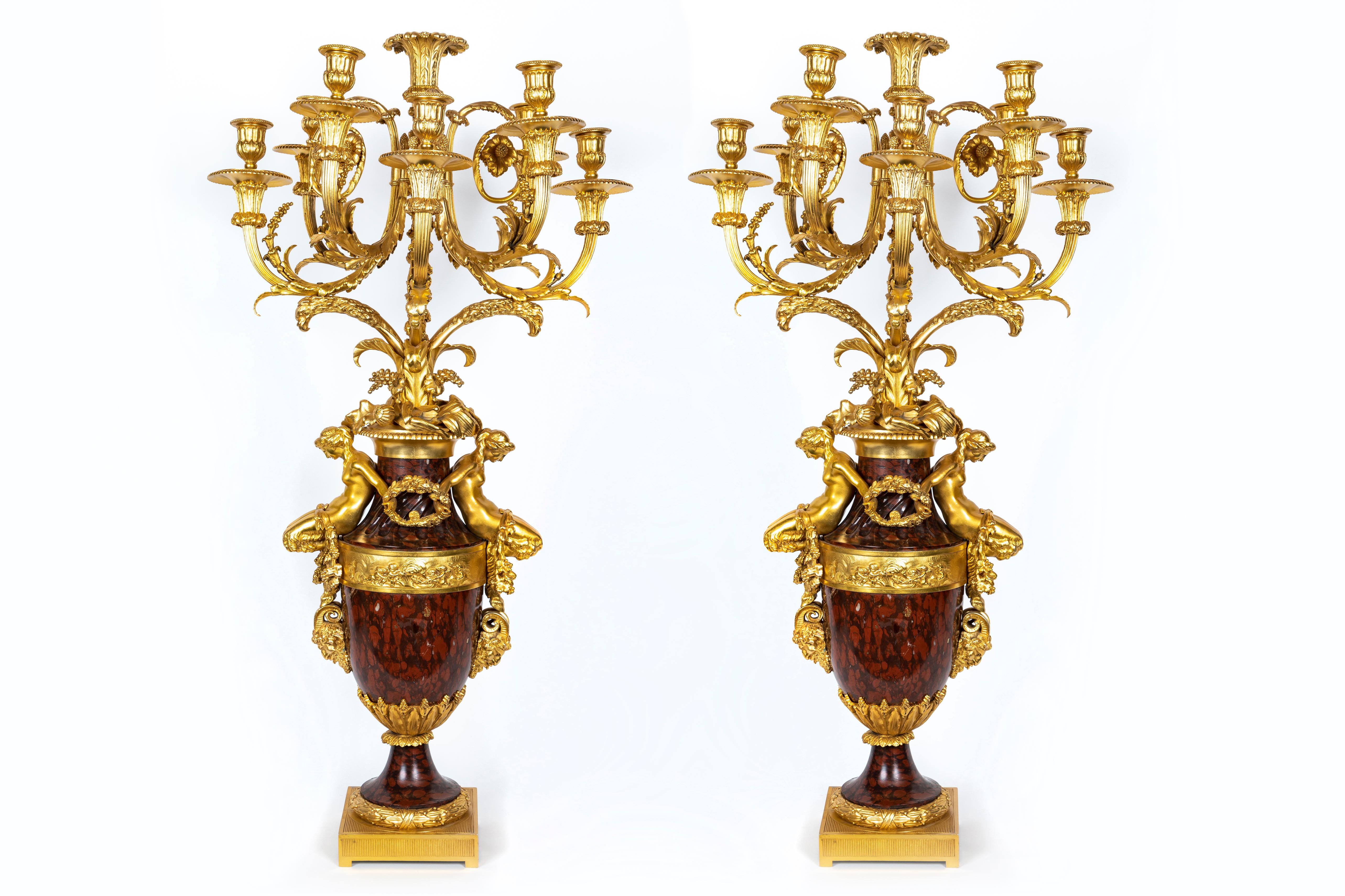 A Pair of highly important and large Magnificent Antique French Louis XVI style figural gilt bronze mounted hand carved rouge marble multi arm candelabras of exquisite craftsmanship attributed to Henry Dasson. Each large candelabra is embellished
