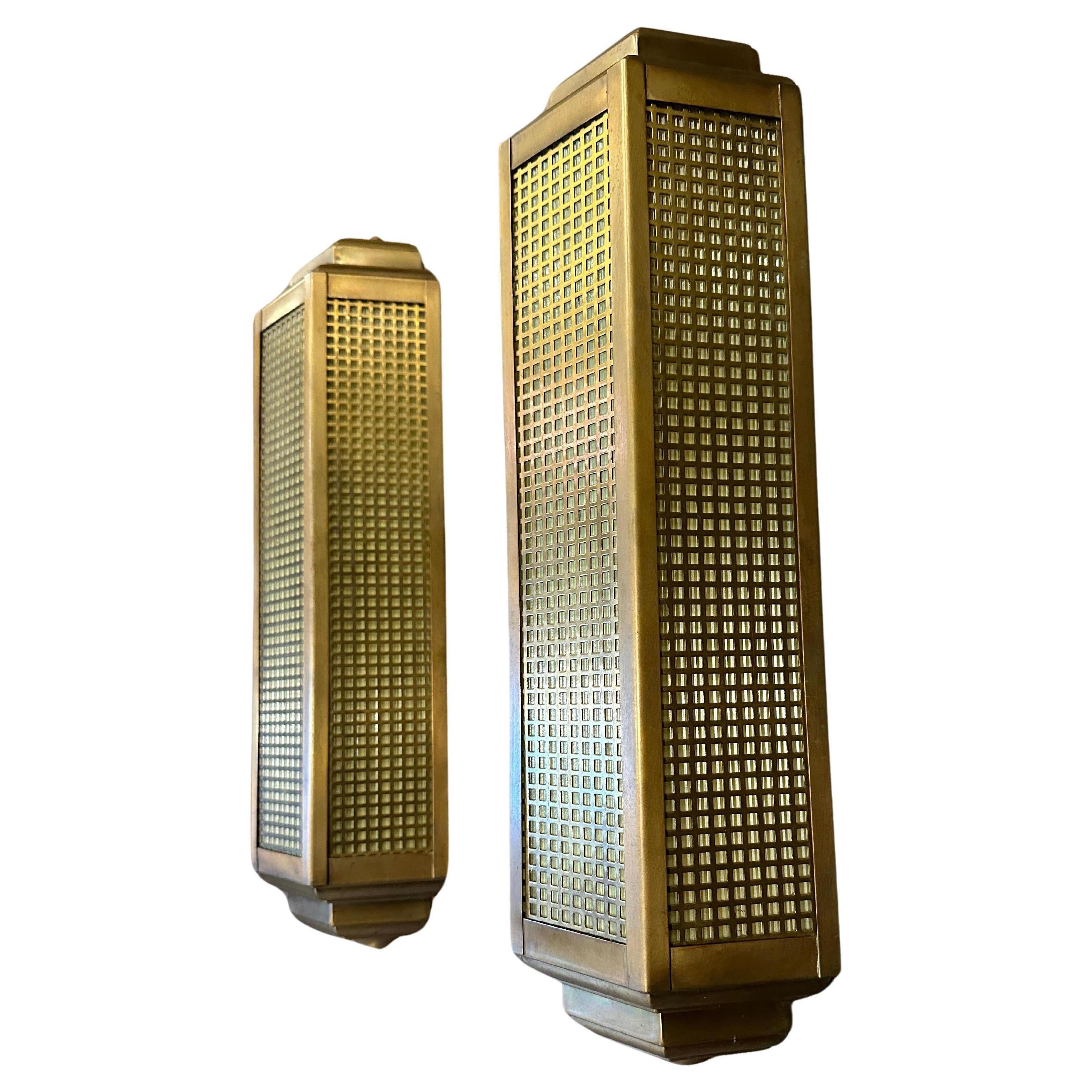 A Pair of late 20th century Art Deco style wall lights In brass and glass. The yellow ribbed glass behind the grid style diffuser, with two light points within and rear mount plates. Continental Circa 1980 