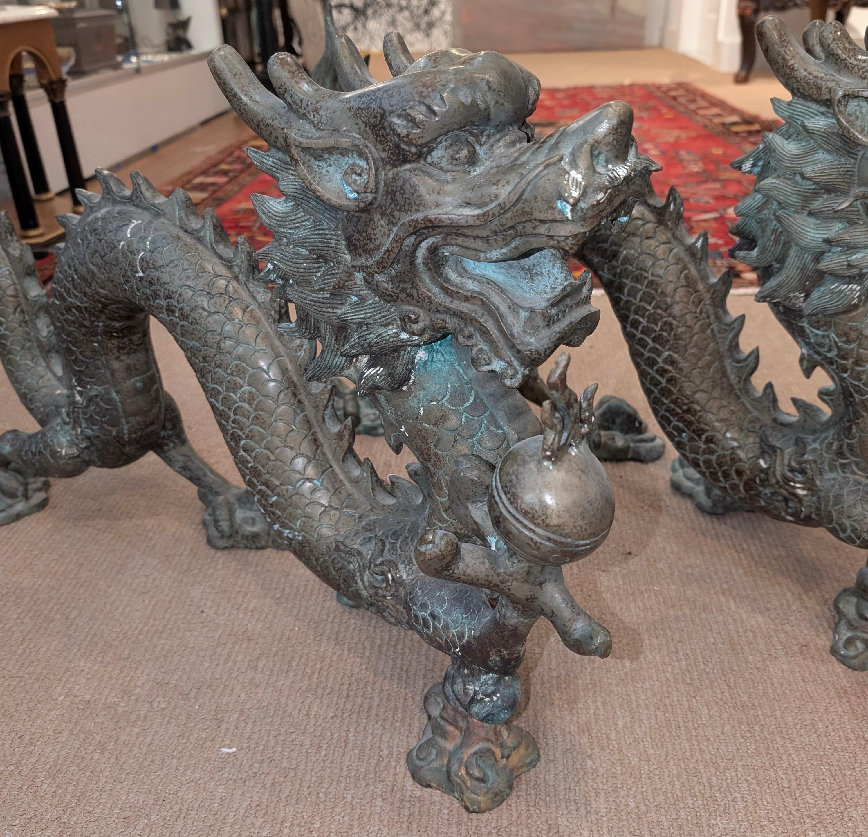 Paire de dragons chinois en bronze à la finition fortement oxydée.  La paire de bronze coulé de forme de dragon mythique 35 pouces de long, 17,5 pouces de haut, 10 pouces de profondeur.  