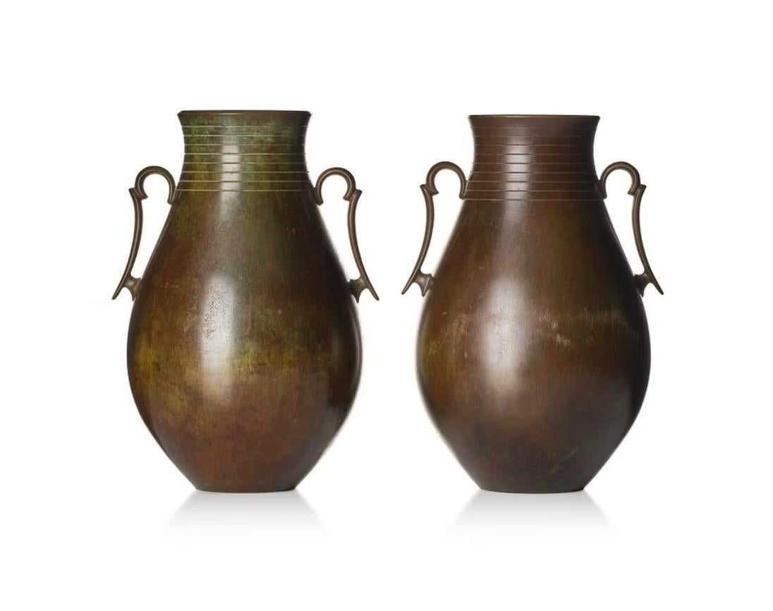 Coppia di grandi vasi svedesi in bronzo Grace, probabilmente disegnati da Jacob Ängman. Prodotto da GAB, Svezia, circa 1930.
Bronzo patinato marrone-verde, forma bulbosa con manici e decorazione a strisce orizzontali, marchio del produttore e numero