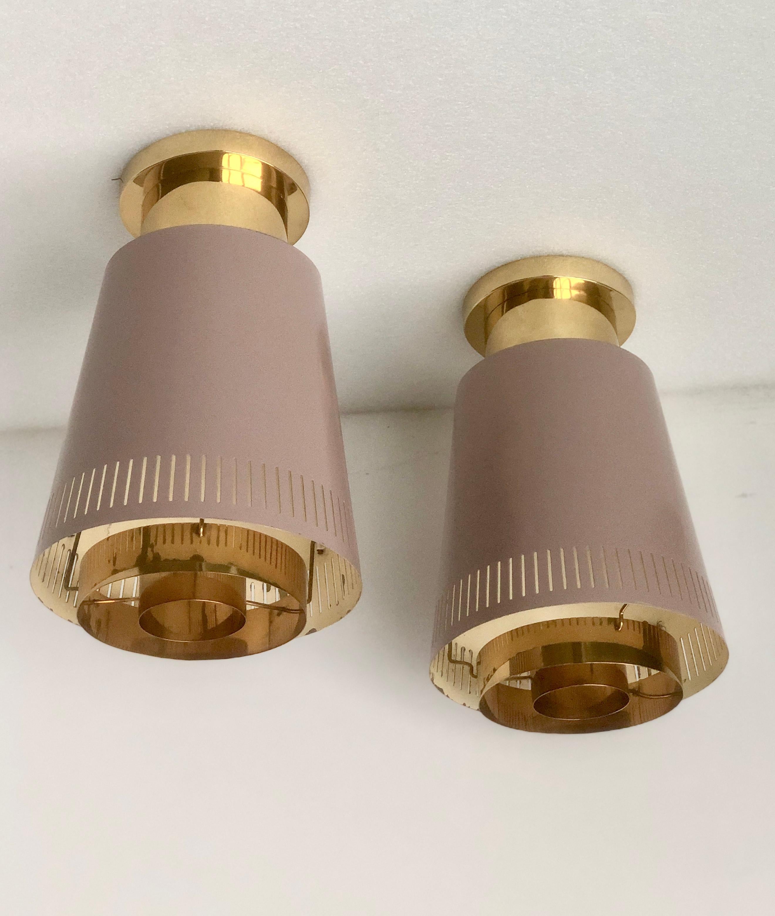 Paavo Tynell designed a pair of large, rare available version of ceiling light , Model 9067, manufactured by Taito Oy, Circa 1950th.
Painted metal with polished brass base and defusers. 
Stamped 
