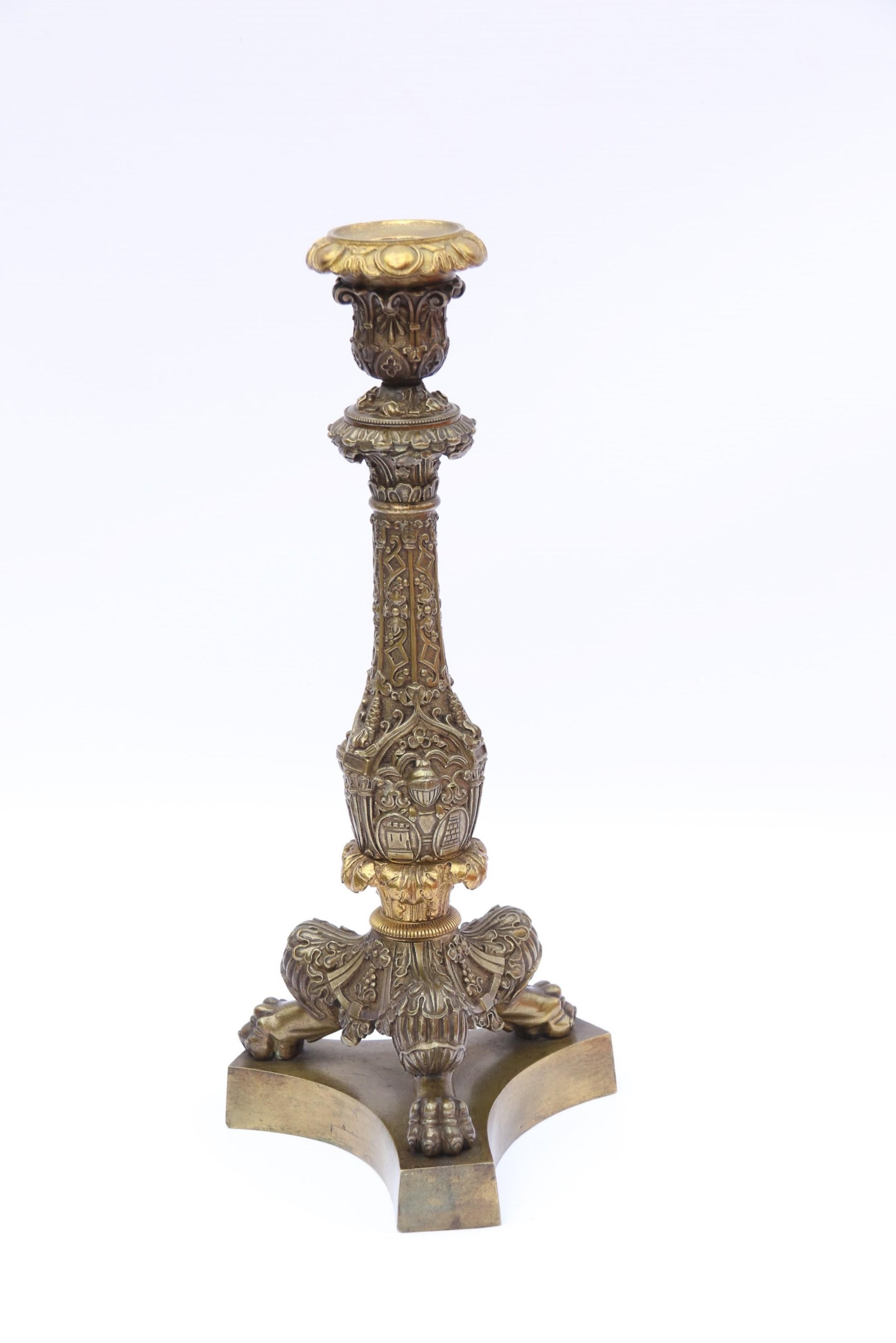 This large bold and decorative pair of mid-19th century candlesticks are most unusual as they are in the form of slightly earlier Empire pieces with additional decorative cast detail being enhanced with medieval towers, knights helmets and Gothic