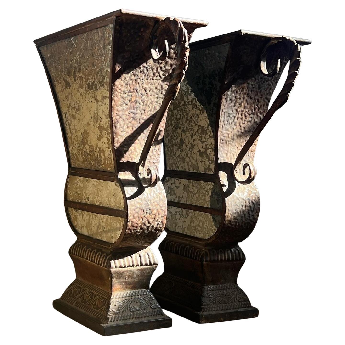A pair of large decorative iron and mirrored urns, 20th century