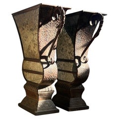 A pair of large decorative iron and mirrored urns, 20th century