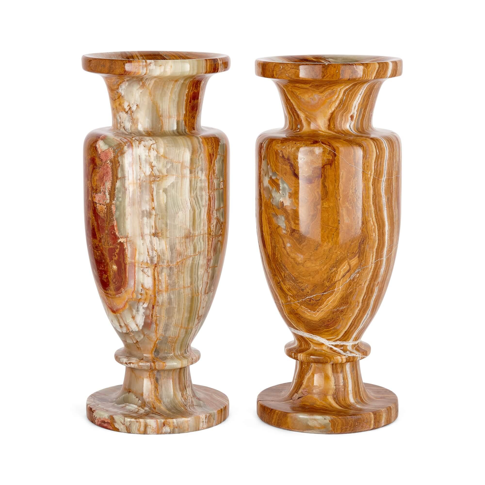 A pair of large decorative vases in red and green onyx
Continental, 20th Century
Height 38cm, diameter 15cm

Elegantly designed and and pristinely finished, these fine vases are carved from green and red onyx, with the natural bands, patterns,