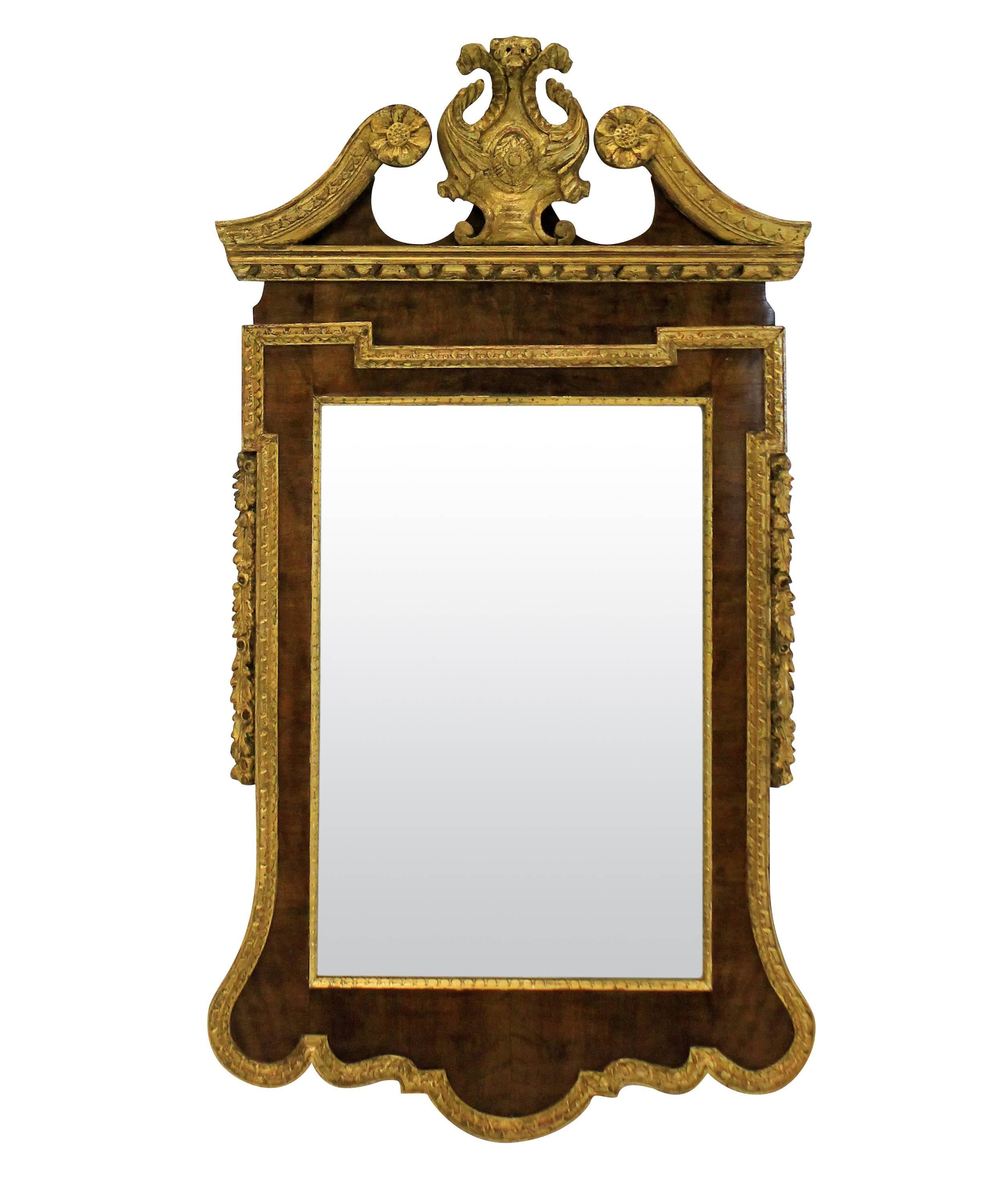 A pair of large English George II style walnut and parcel gilded mirrors.

   