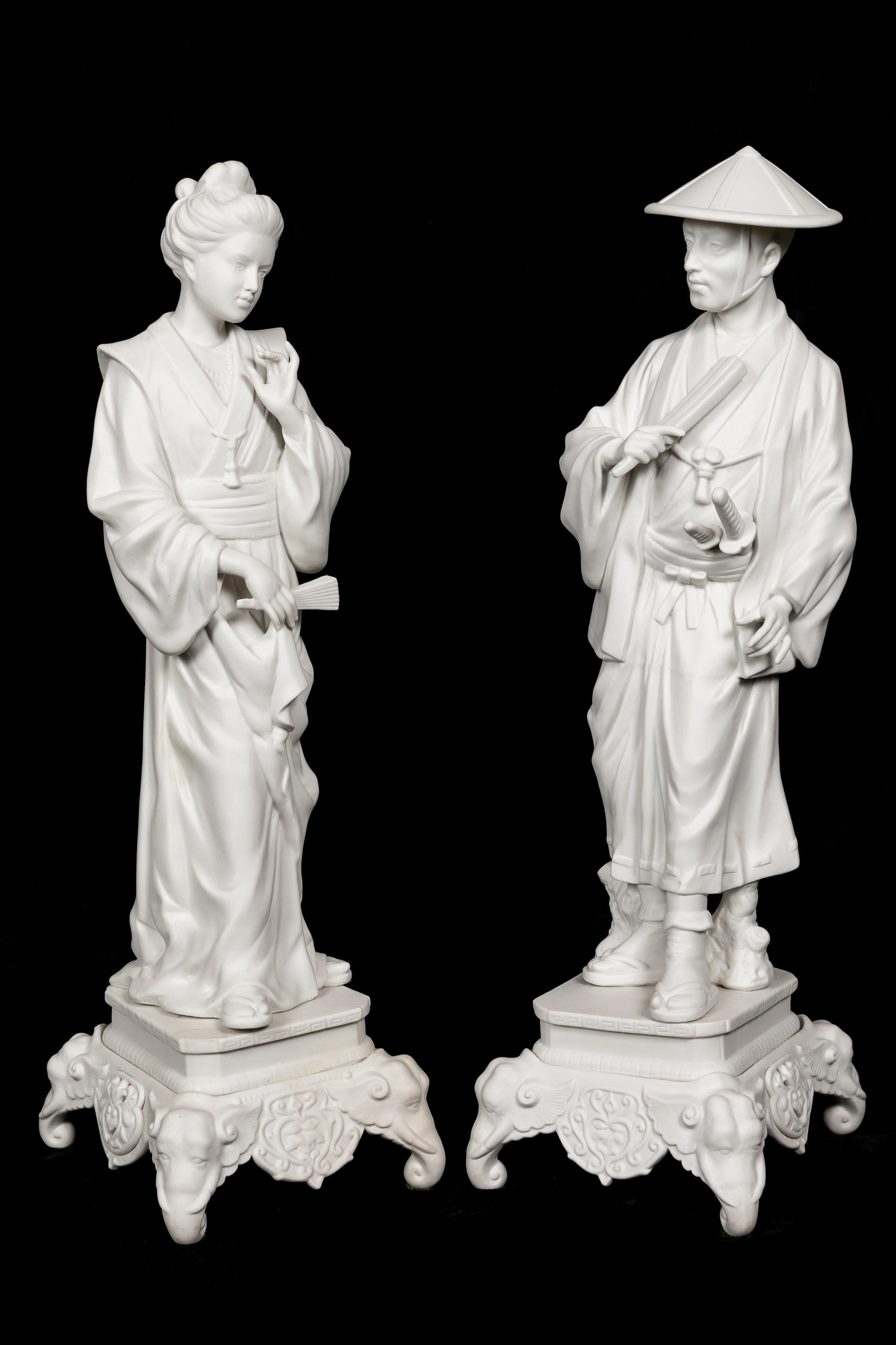 A Pair of Spectacular and Large Antique French Chinoiserie Style white porcelain figures of a male and female figure. Both modelled in white bisque porcelain of chinoiserie style wearing robes and holding fans on square bases embellished with