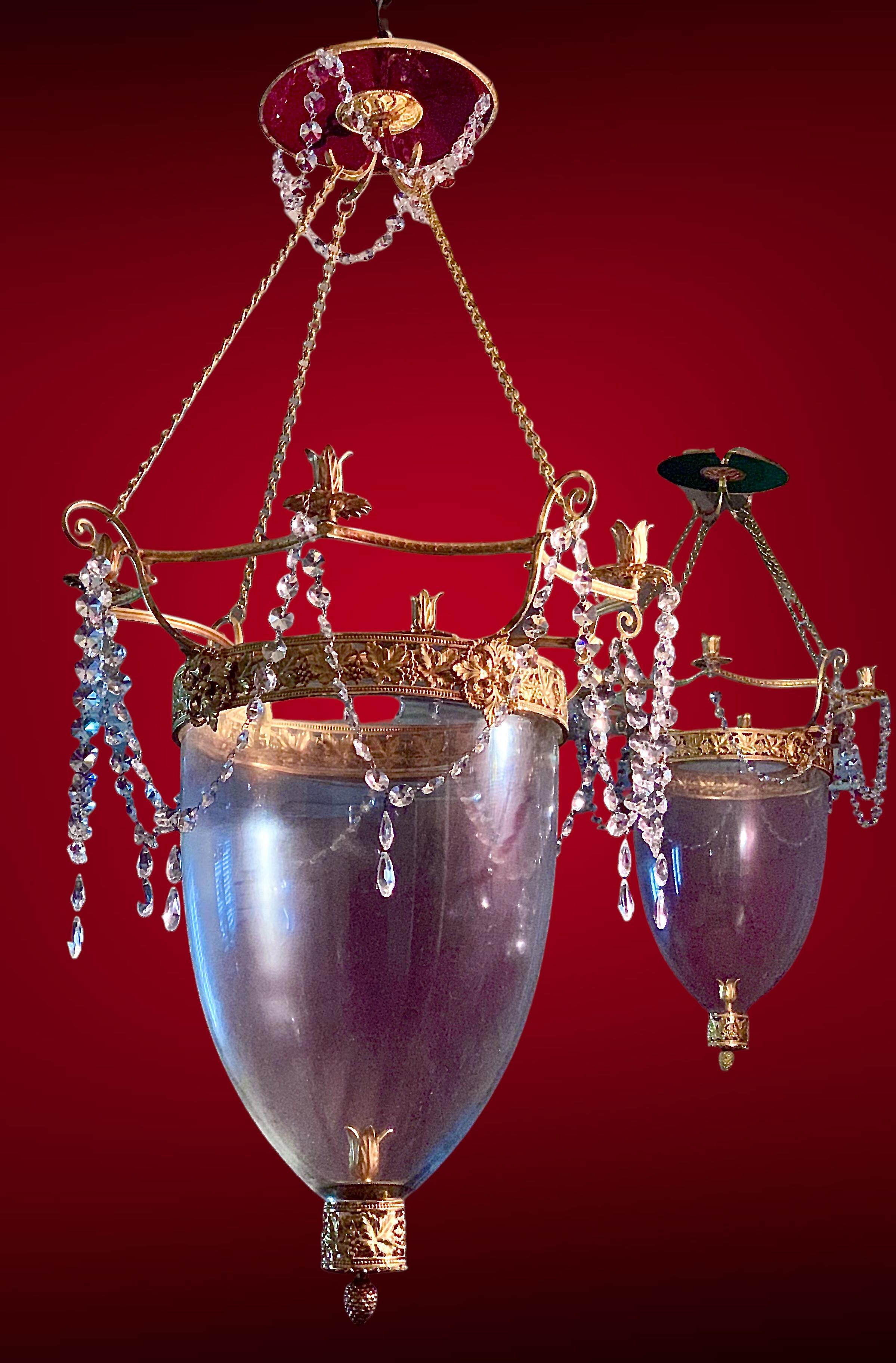 A pair of large Neo classical Lanterns in Baltic Directoire style,  4 lights, clear crystal bowl, overcome by a green crystal disc ,  gilt bronze fixings with foliage and grapes motives. Adorned with crystal almonds chains  and drops. 
Heigh  could