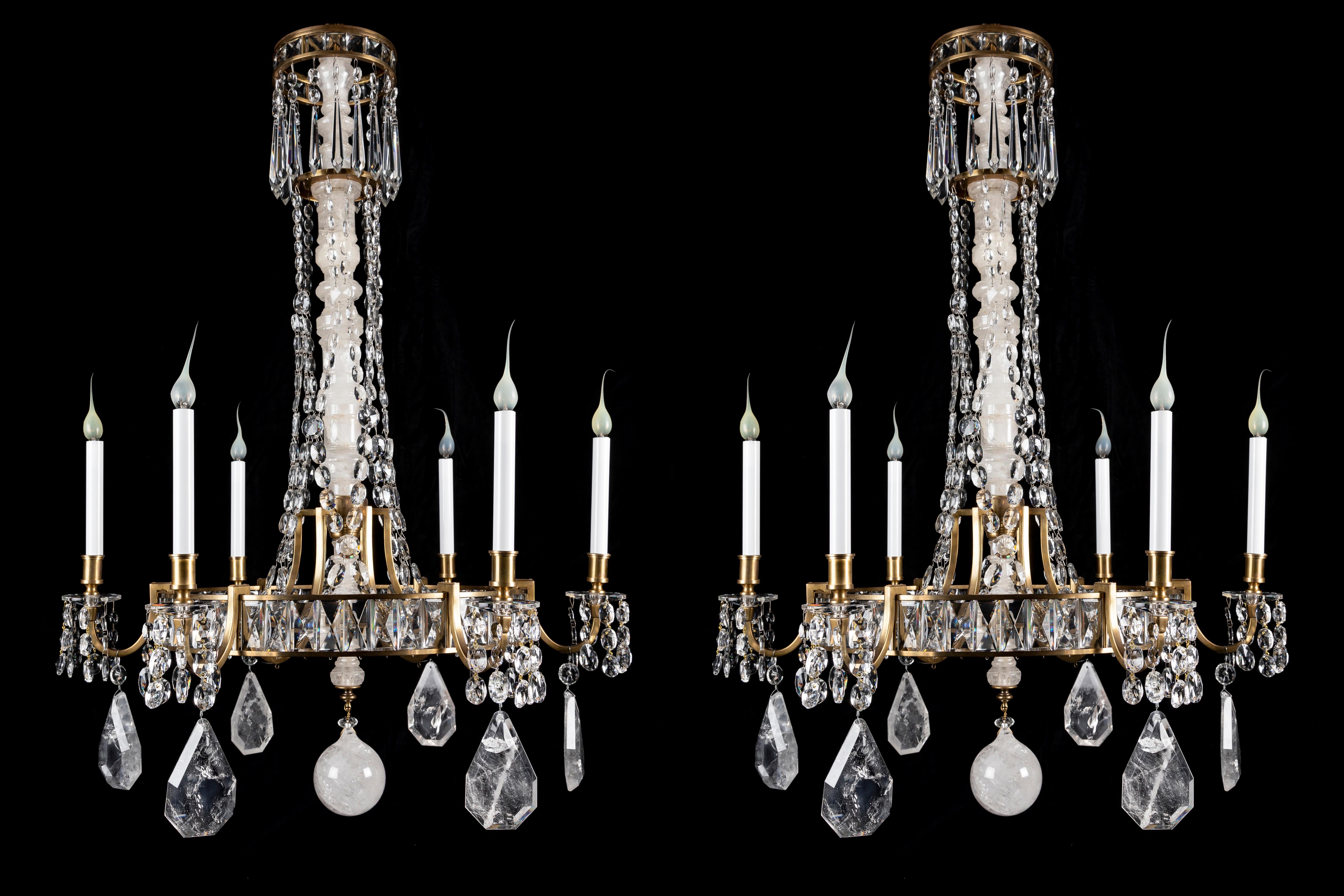 A Pair of Unique Large  French Hollywood Regency Bagues Style circular form gilt bronze, cut rock crystal and crystal multi light chandeliers of fine quality. This pair of  unusual chandeliers are embellished with  a large central shaft of hand