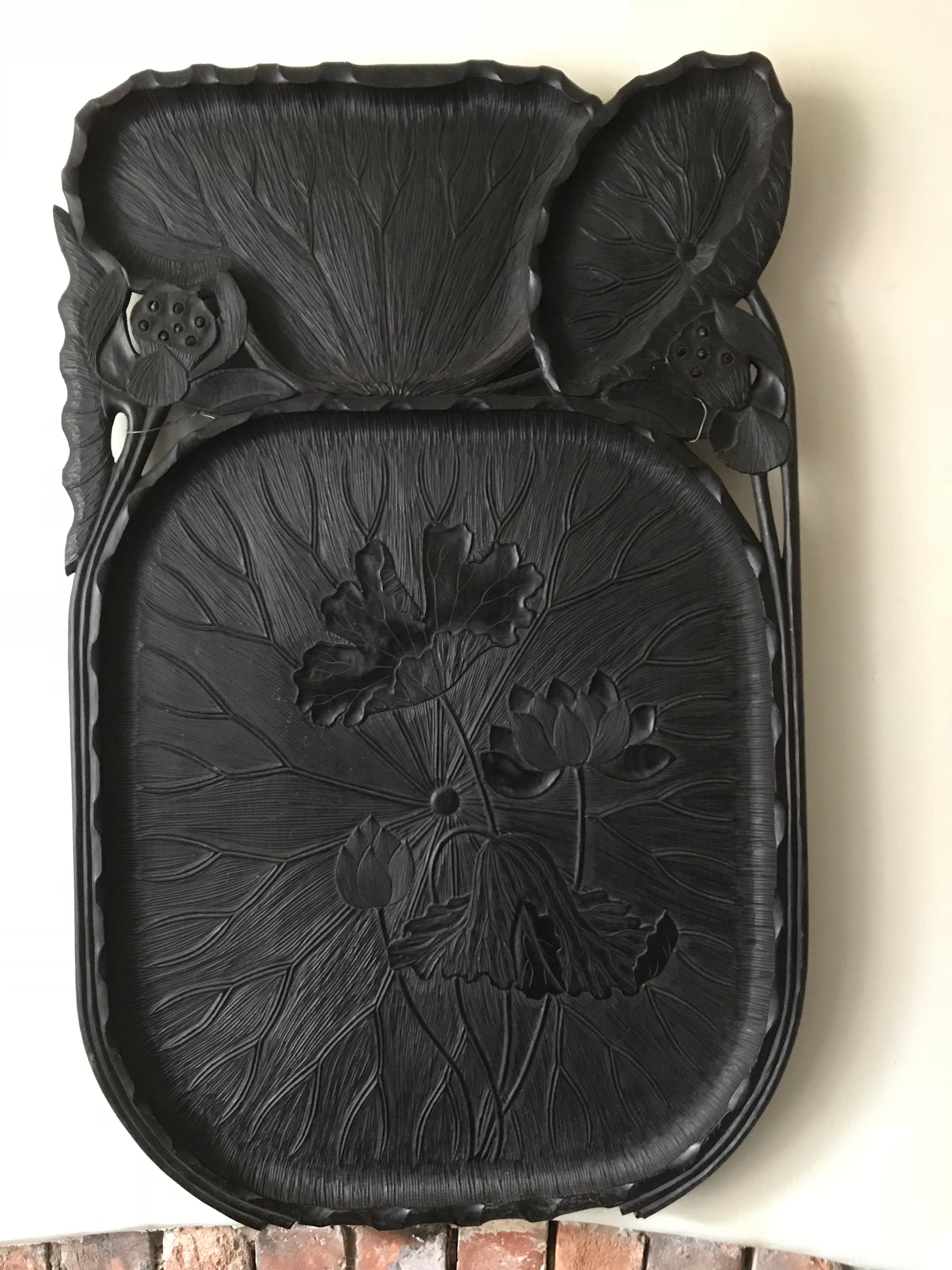 A pair of large wood trays. Each in the form of open lotus leaves together with seed pods and carved in low relief with flowering lotus. The seed pods with loose seeds. The wood with a dark stain. 19th-20th century
Measures: Length 32