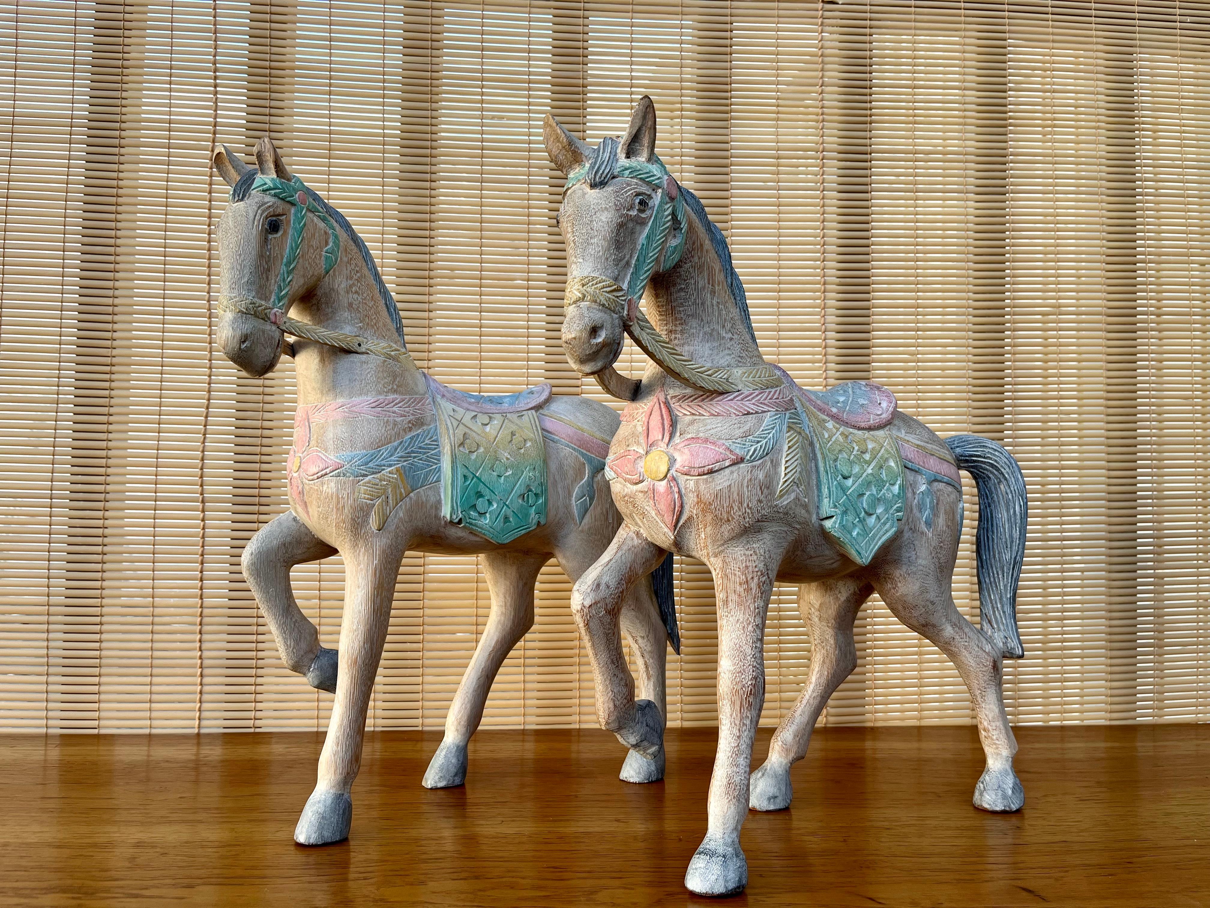 A pair of large Late 20th Century Thai hand carved wooden horse sculptures. Circa 1980s 
Feature two horses trotting, carved from single piece of wood and hand painted in a traditional South Eastern Asian pastel palette color style. 
In excellent