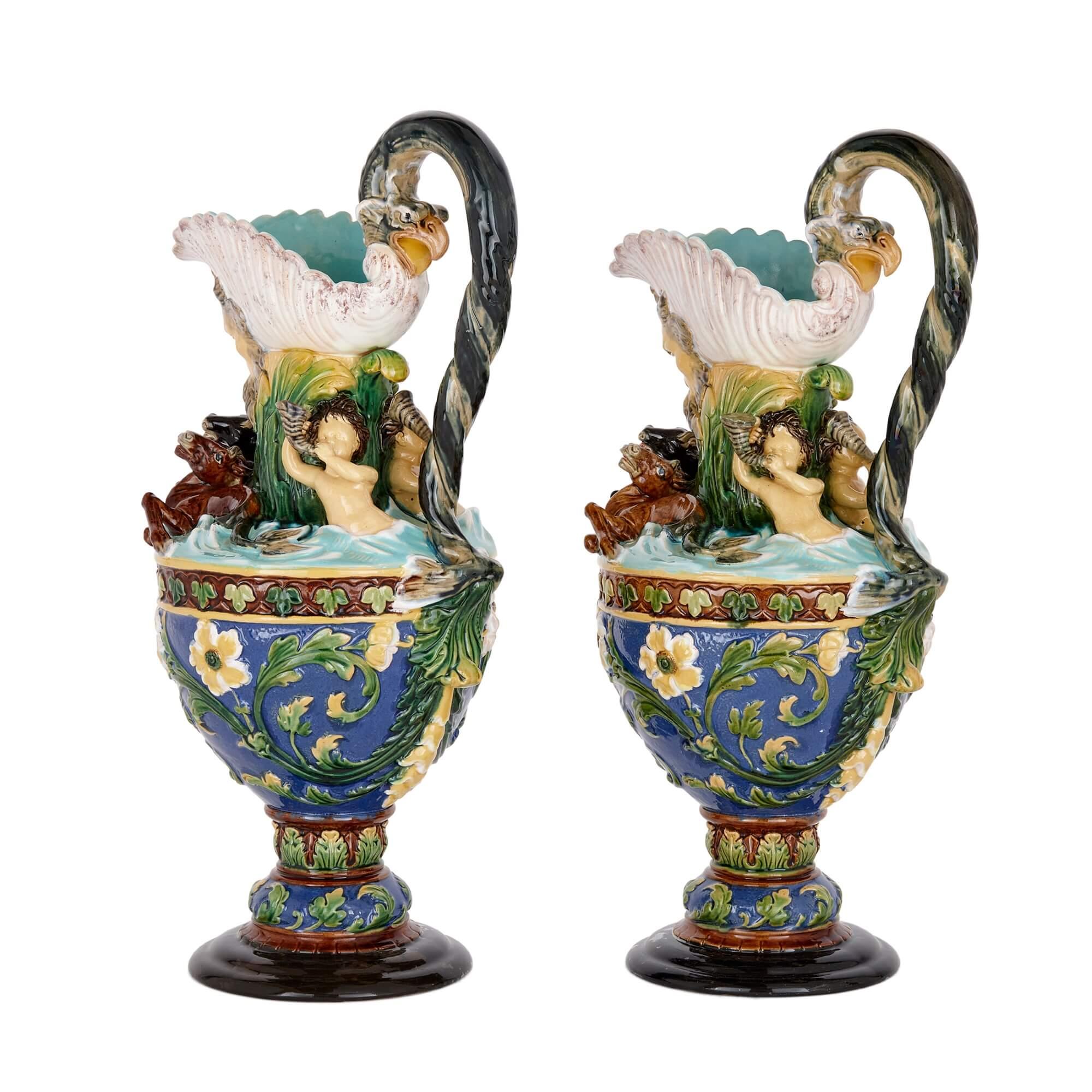 A pair of large majolica ewers by Wilhelm Shiller und Söhne
Bohemian, Late 19th Century
Measures: Height 45cm, width 23cm, depth 18cm

With spouts formed as upturned shells, moulded masks with issue forth eagle-head and serpent tail handles,