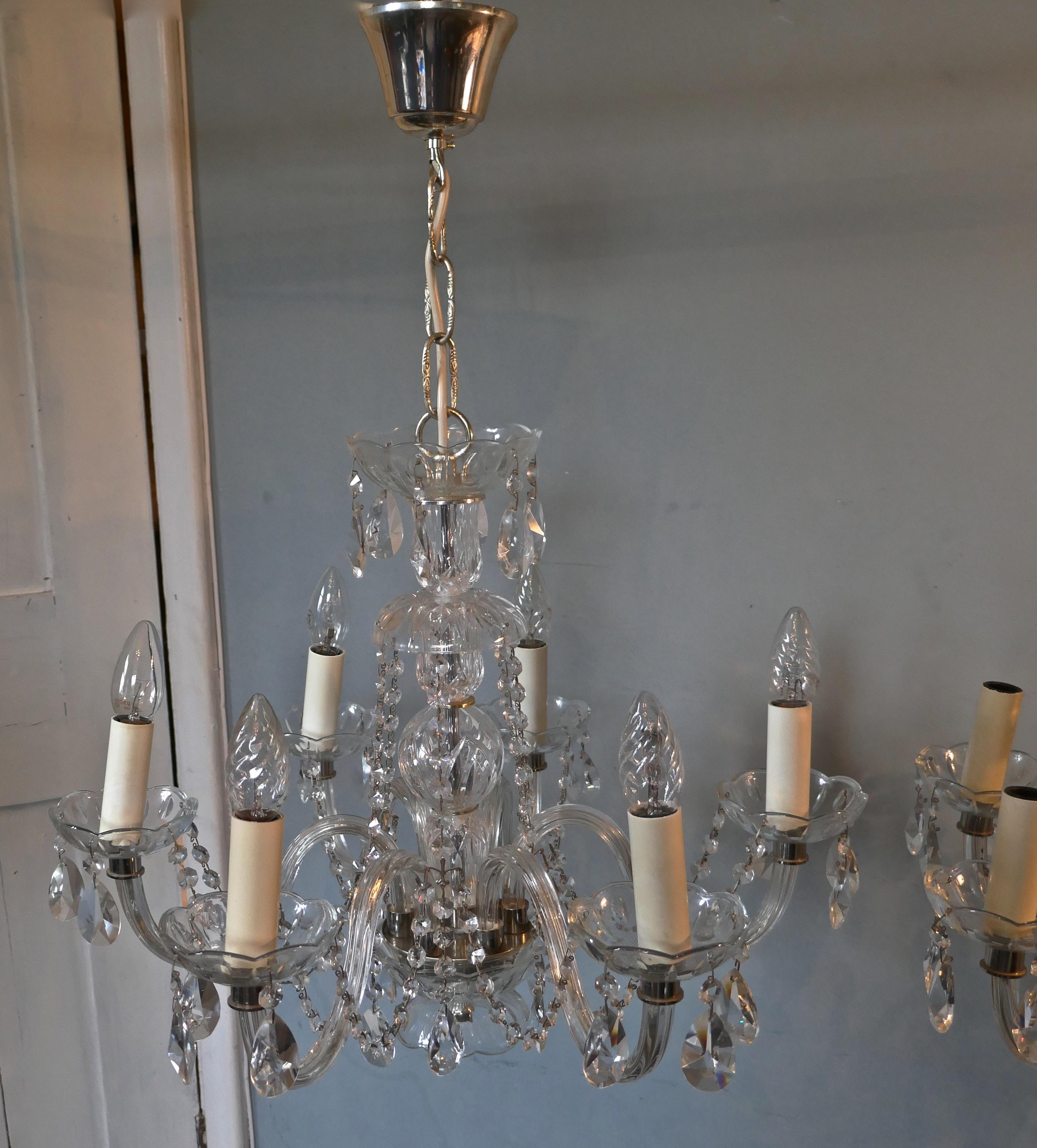 A pair of large rainbow crystal 6-branch chandeliers

These are fine quality pieces, they each have beautifully cut baluster columns and 6 branches which are sheathed in finely cut glass.
Each chandelier is hung with pear drop crystal lusters and