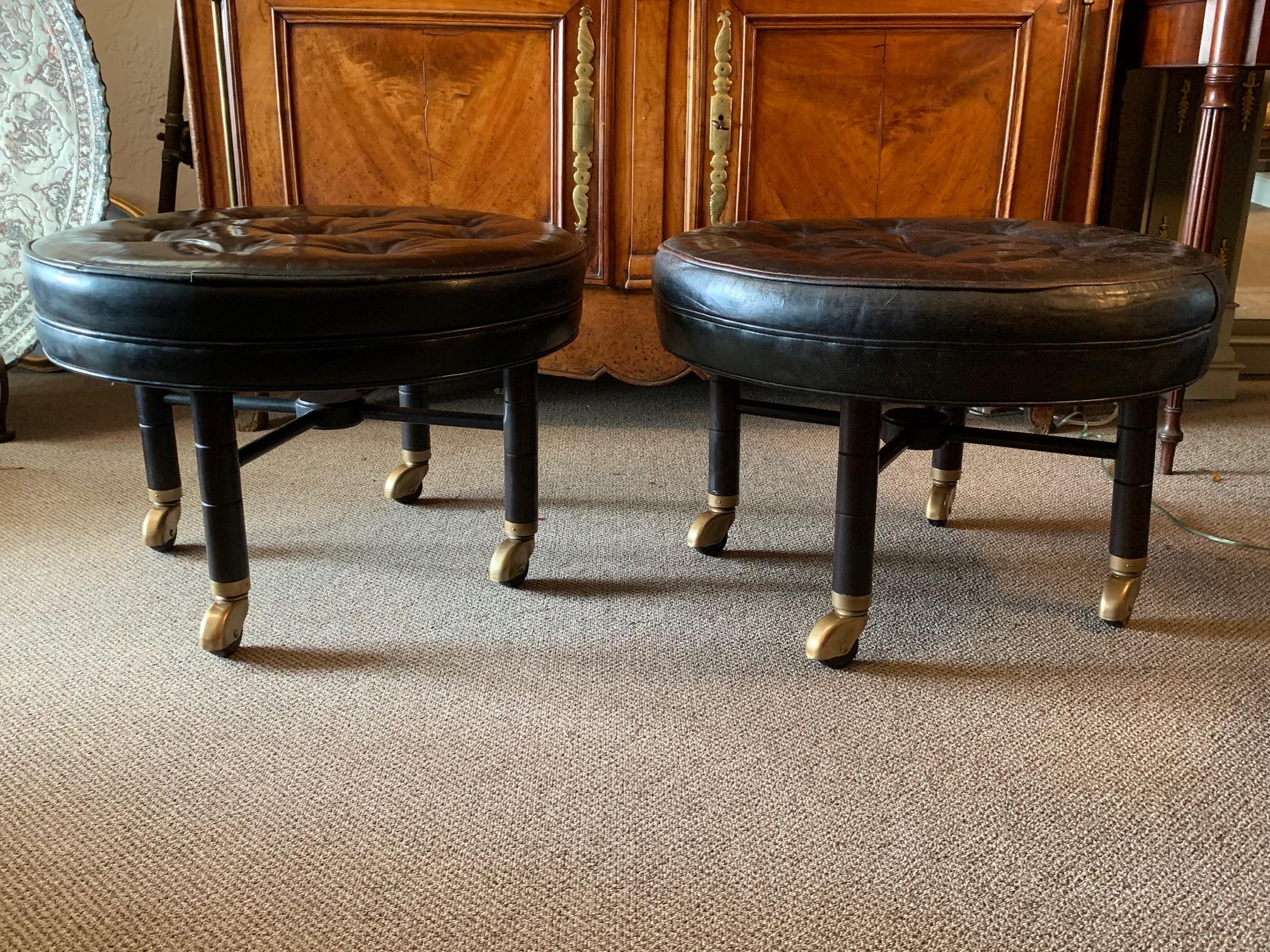 A pair of classic large scale ottomans by Baker on heavy casters. Original black leather tops. Frames restored.