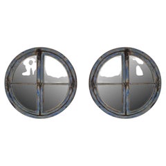 A pair of large round mirrored windows with wooden frames France, 18th century.